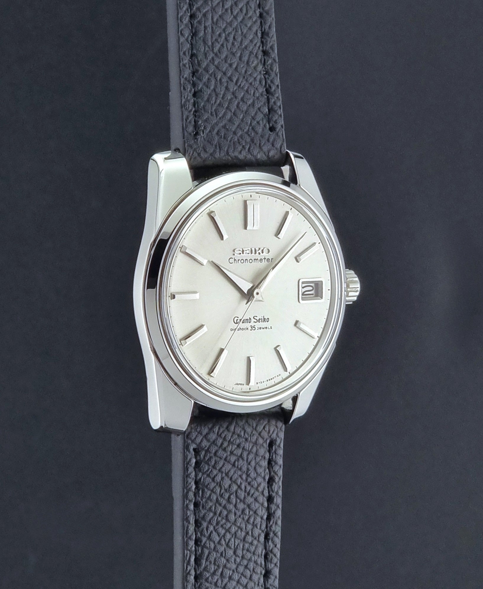 Vintage Grand Seiko Wristwatch 43999 leather strap on a gray background side profile view