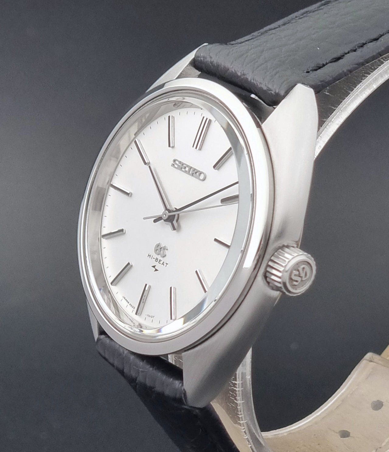Grand Seiko watch 4520-7010 with black leather strap and silver case on a  on a dark surface crown view