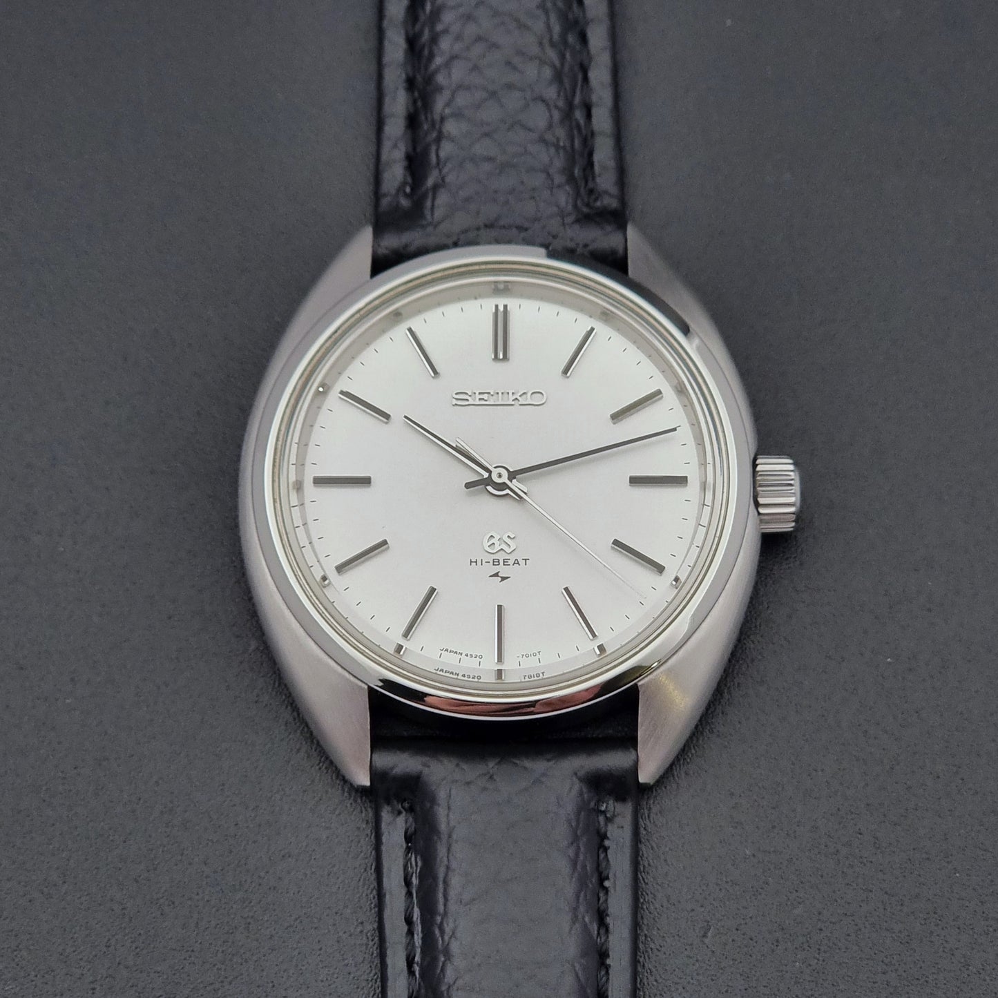 Grand Seiko watch 4520-7010 with black leather strap and silver case on a  on a dark surface dial close up
