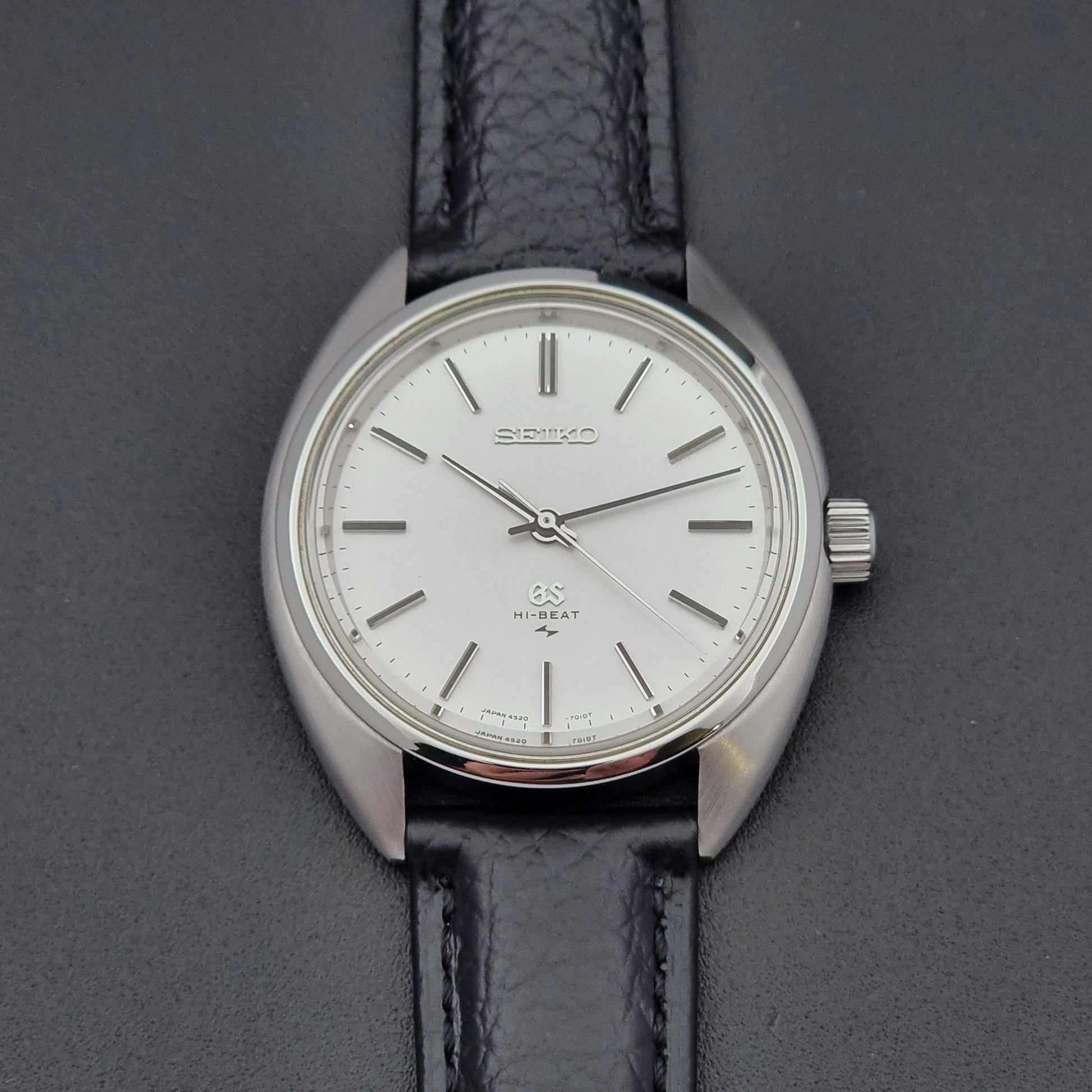 Grand Seiko watch 4520-7010 with black leather strap and silver case on a  on a dark surface dial close up