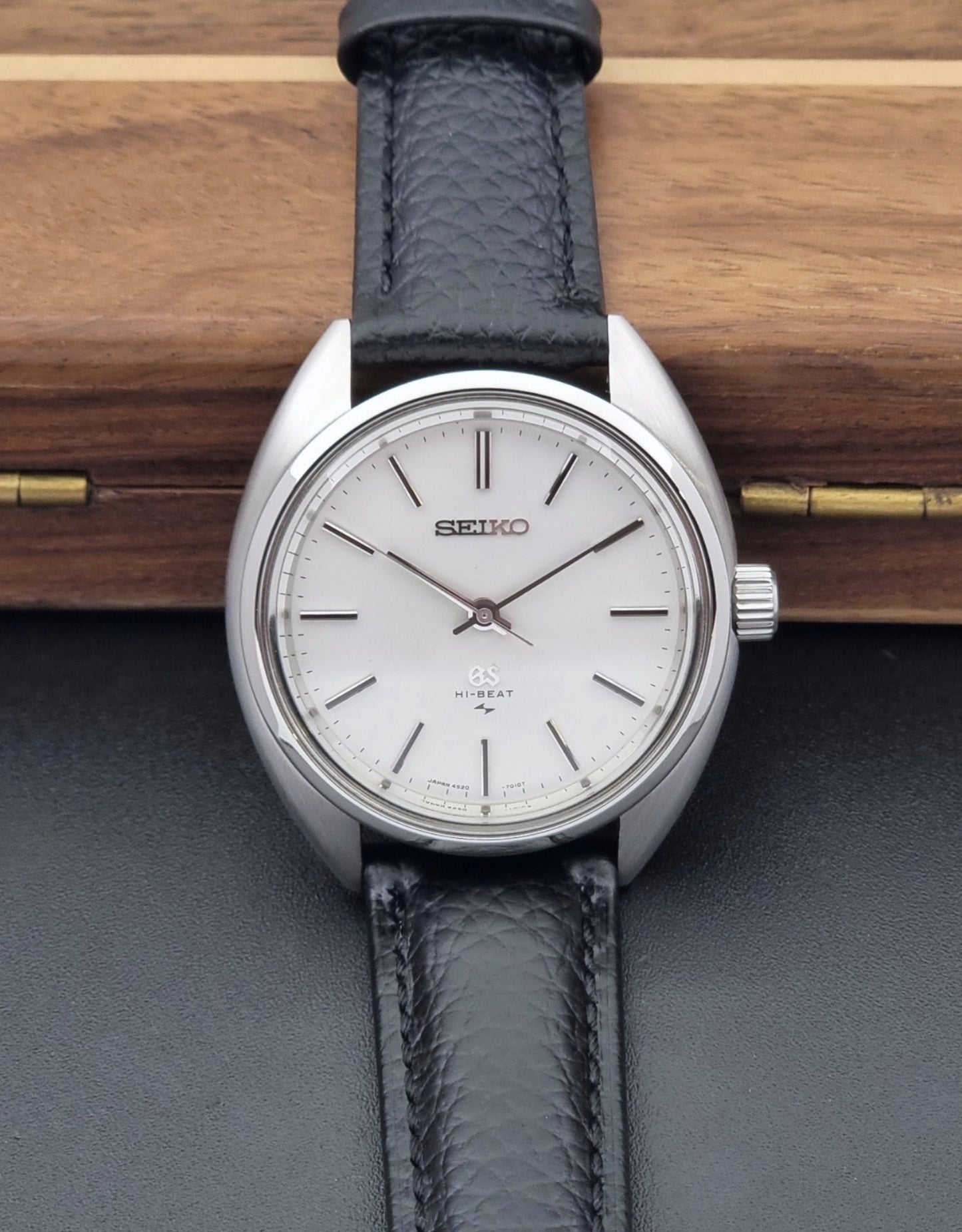 Grand Seiko watch 4520-7010 with black leather strap and silver case on a wooden surface front