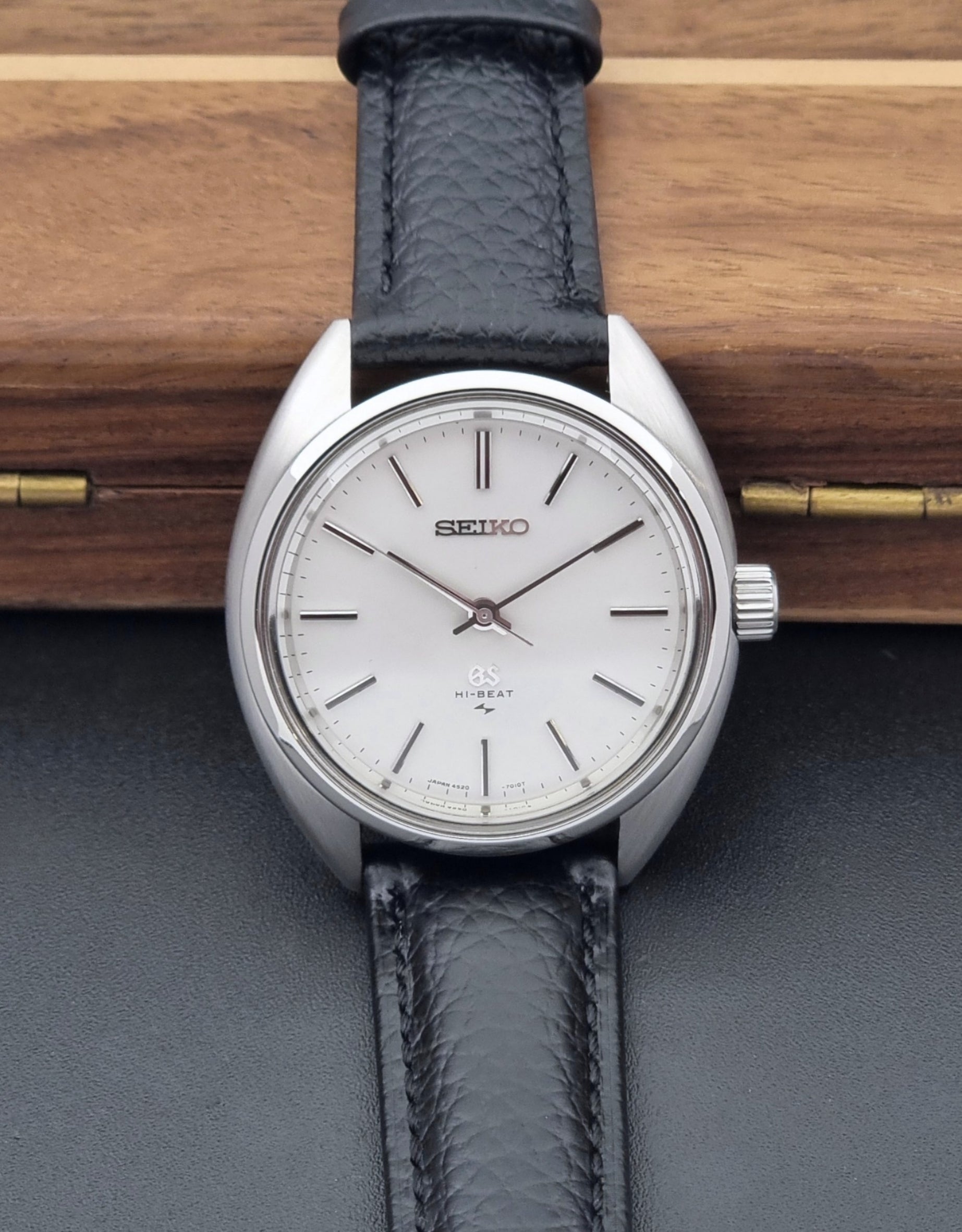 Grand Seiko watch 4520-7010 with black leather strap and silver case on a wooden surface front