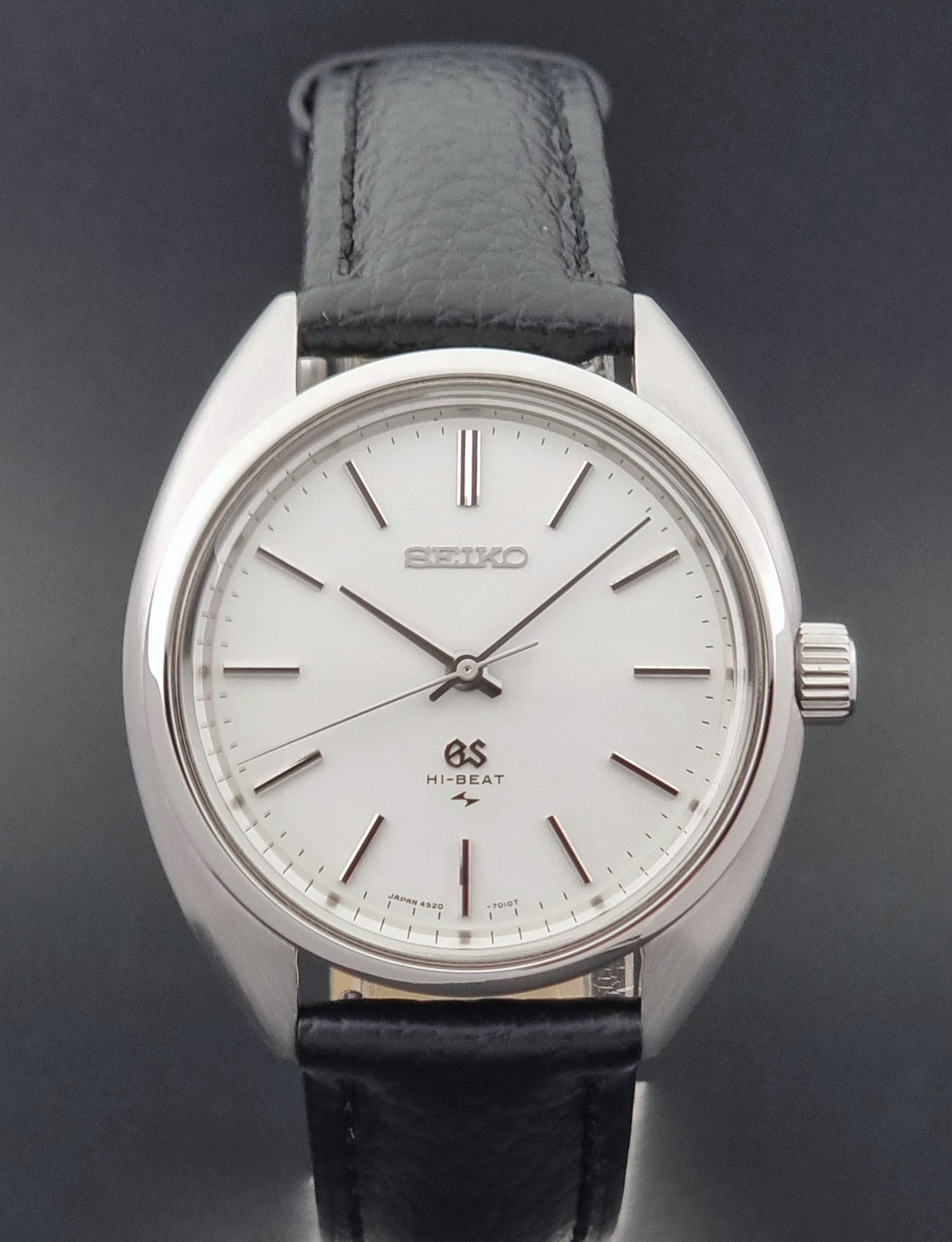 Grand Seiko watch 4520-7010 with black leather strap and silver case on a  on a dark surface close up
