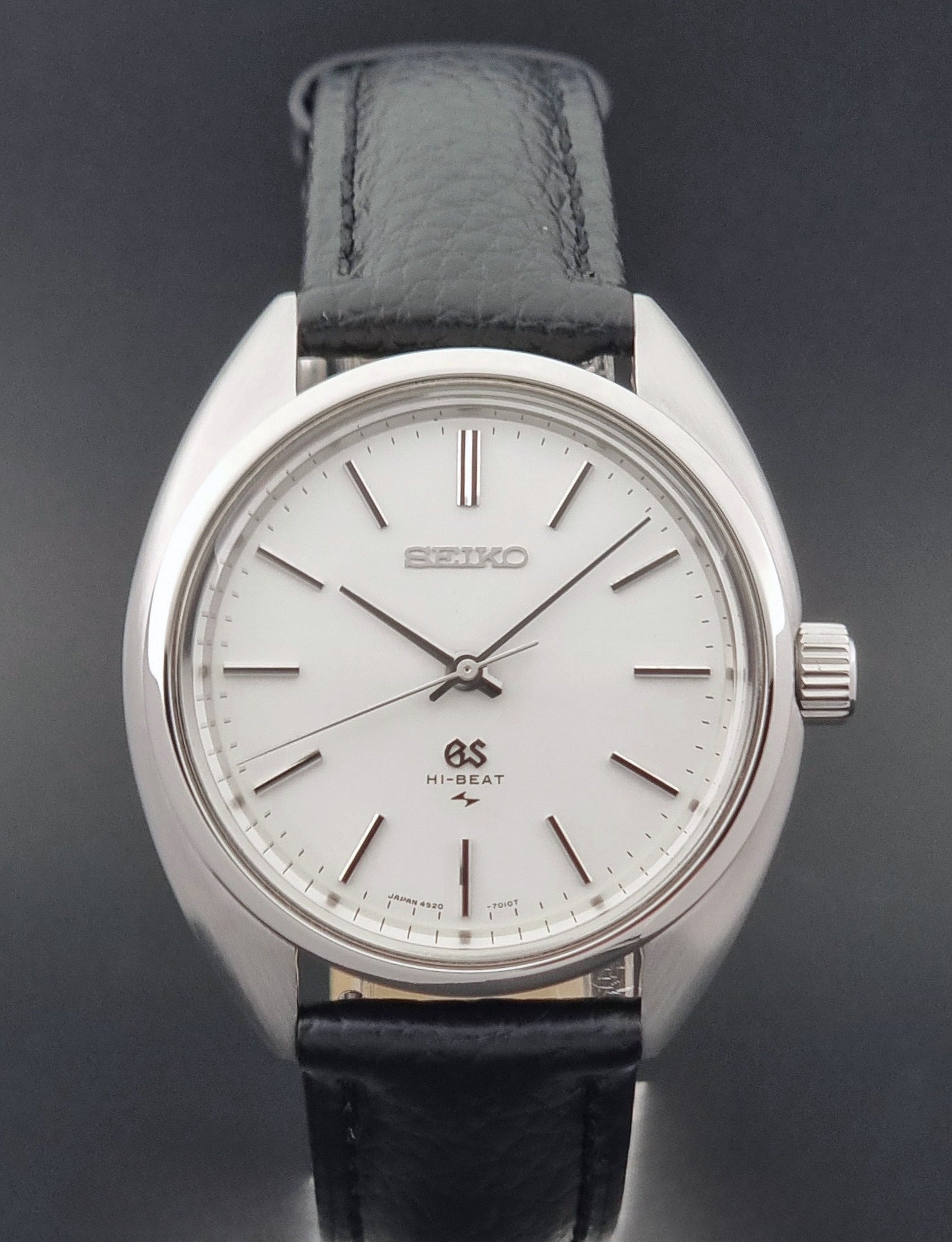 Grand Seiko watch 4520-7010 with black leather strap and silver case on a  on a dark surface close up
