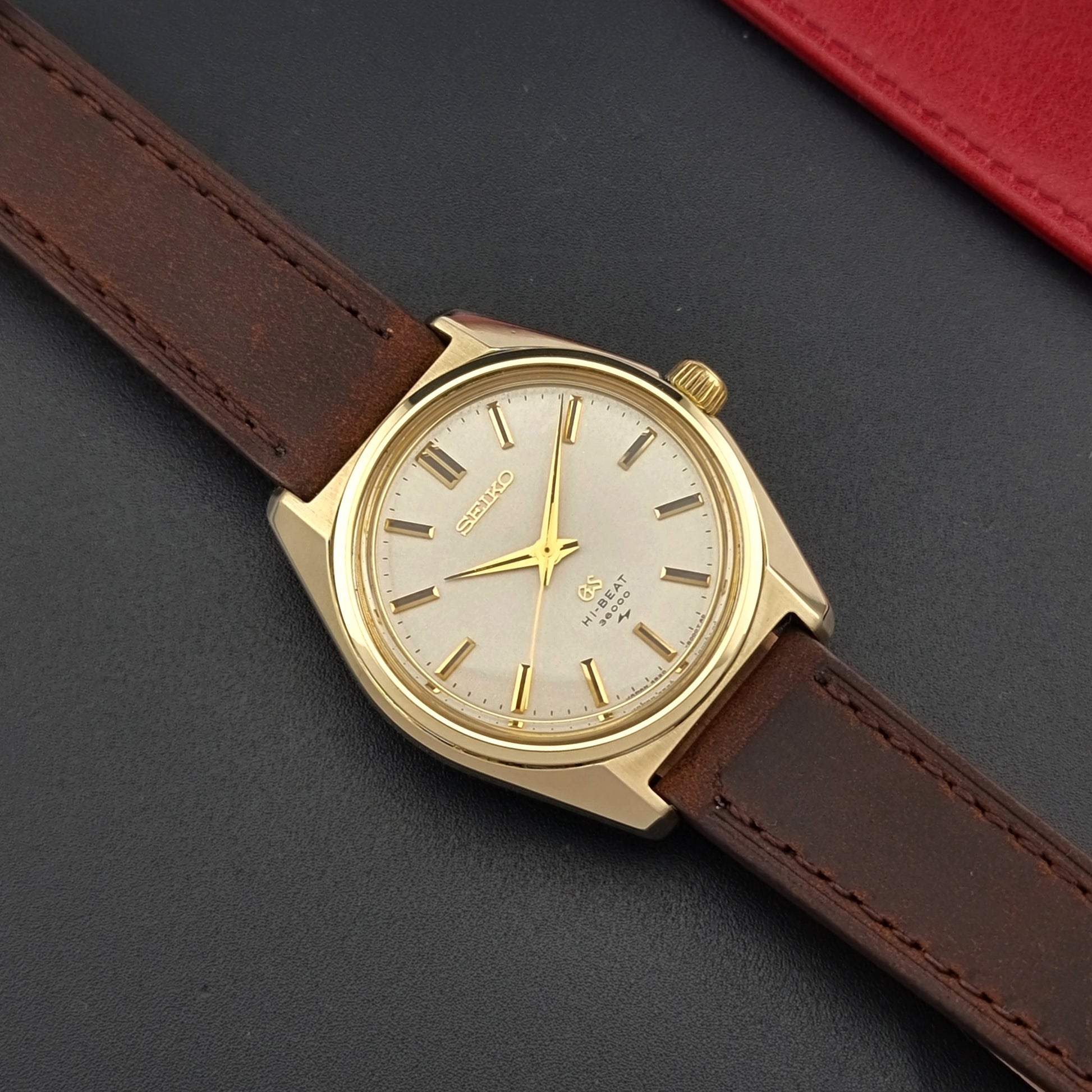 Vintage Grand Seiko 4520-8000 gold watch with brown leather strap on a dark background