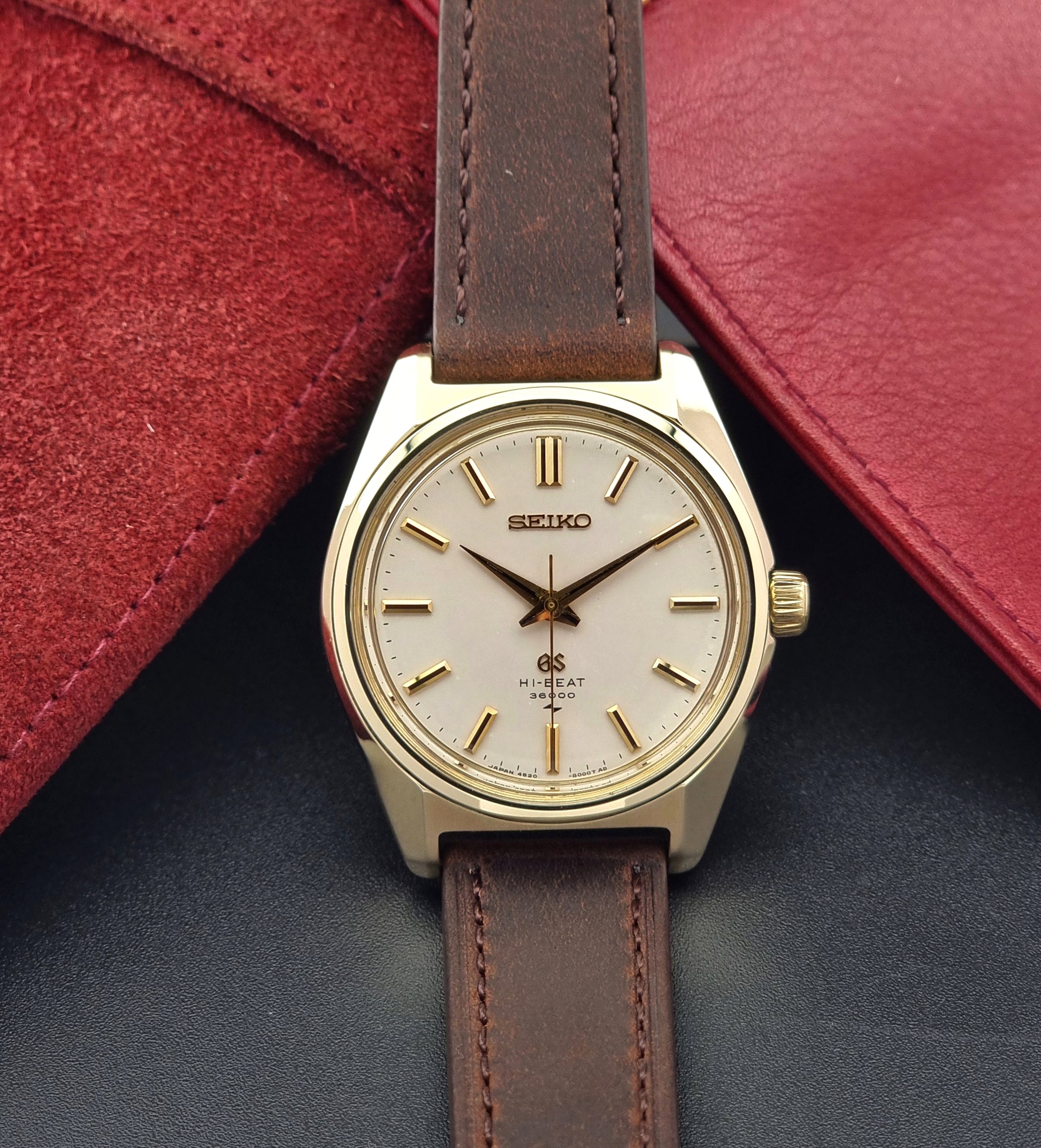 Vintage Grand Seiko 4520-8000 gold watch with brown leather strap on a dark background front view