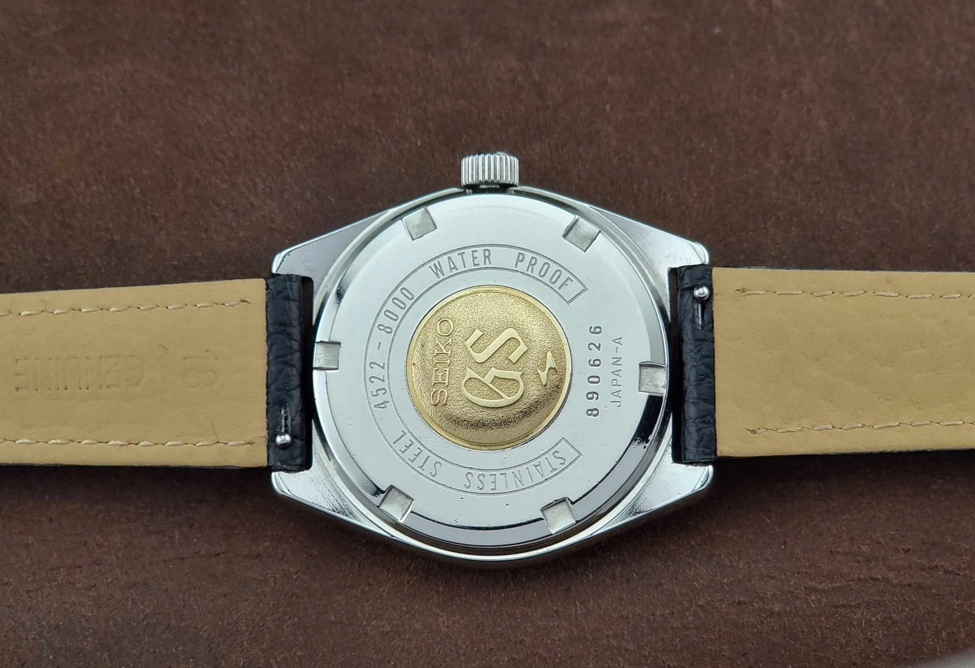 Close-up of a Vintage Grand Seiko watch case back on a brown background