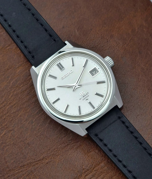 Vintage Grand Seiko 4522-8000 watch with black strap on a wooden surface