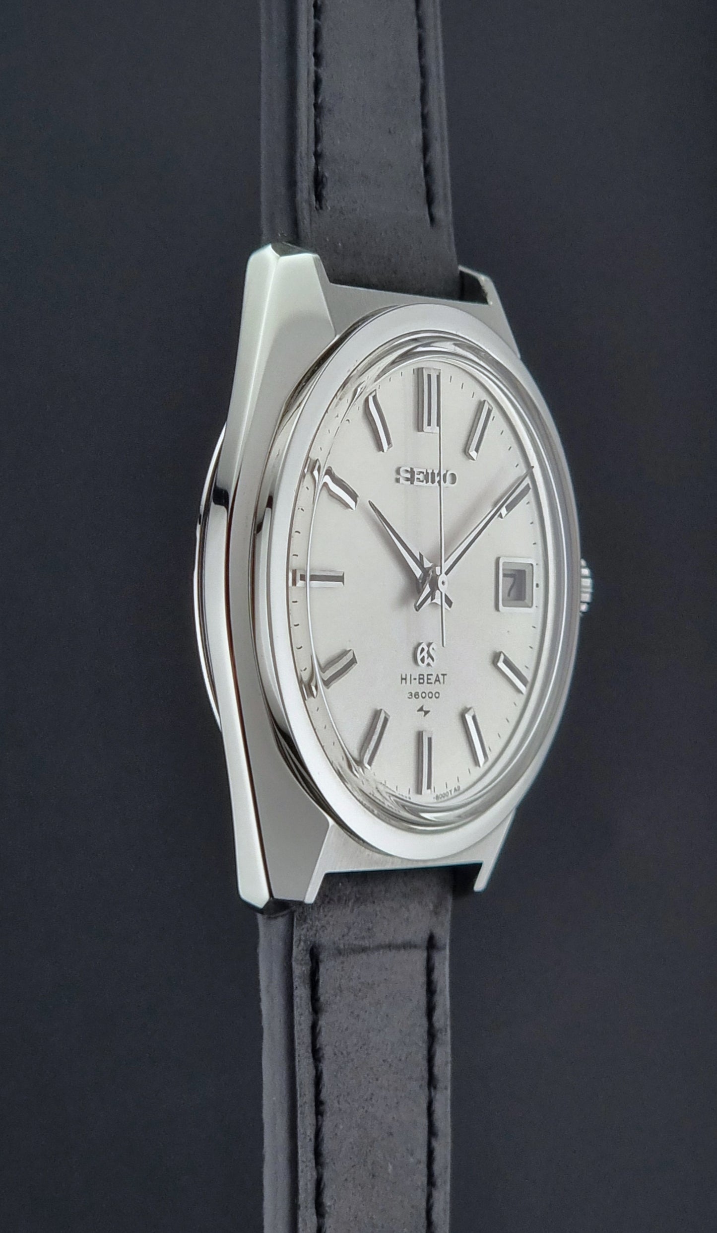 Vintage Grand Seiko 4522-8000 Watch with silver case and black leather strap on a dark background