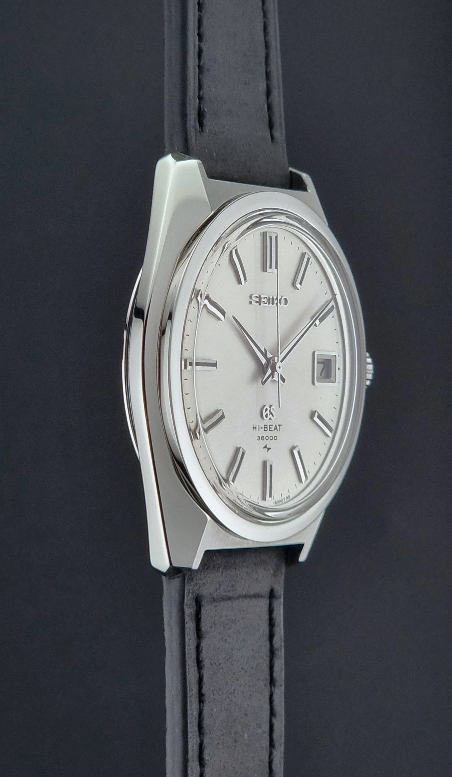 Vintage Grand Seiko 4522-8000 Watch with silver case and black leather strap on a dark background