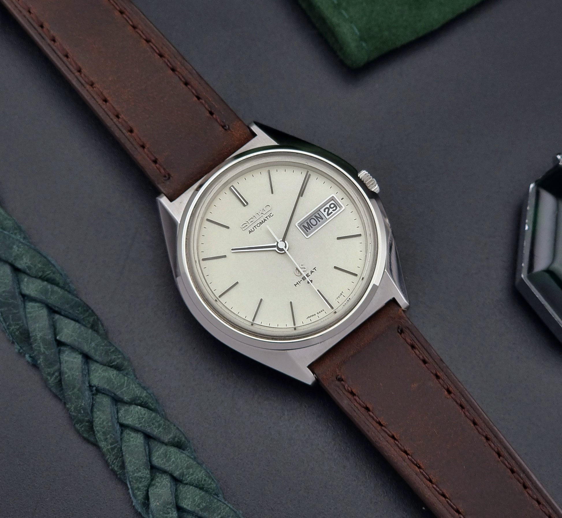Vintage Grand Seiko Watch with brown leather strap on a gray surface