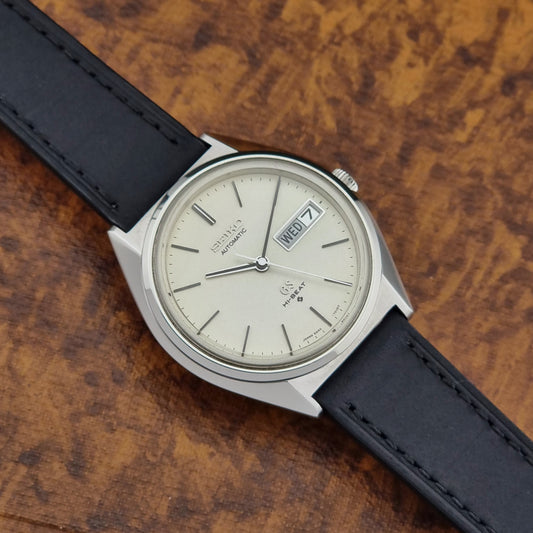 Vintage Grand Seiko 5646-7011 Wristwatch with black leather strap on a wooden surface