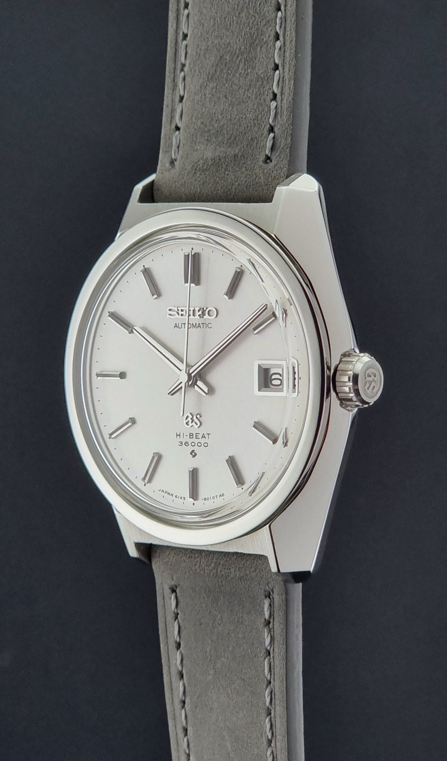 Grand Seiko 6145-8000 watch with gray strap on a dark background