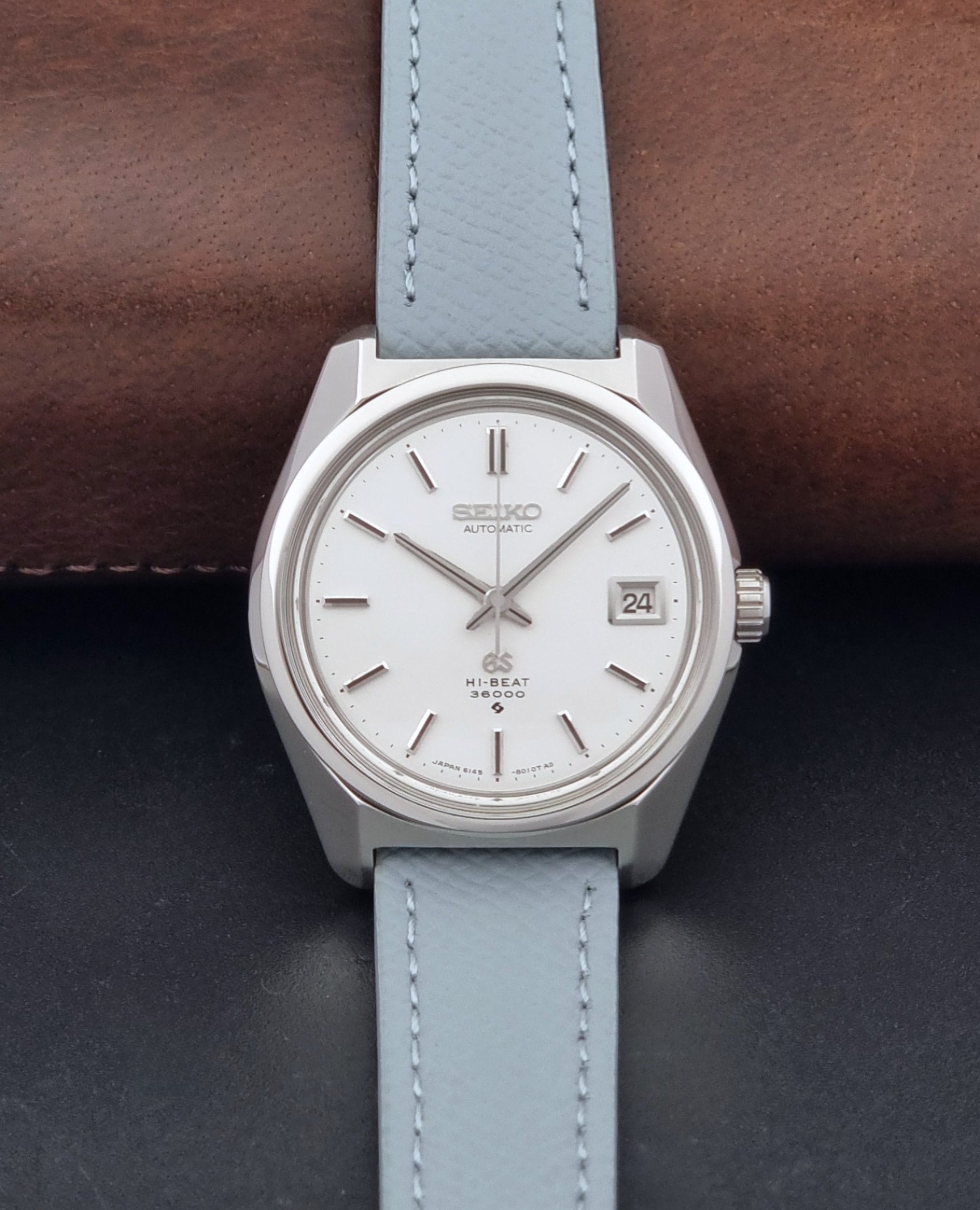 Vintage Grand Seiko 6145-8000 on a grey leather strap on a dark background dial view