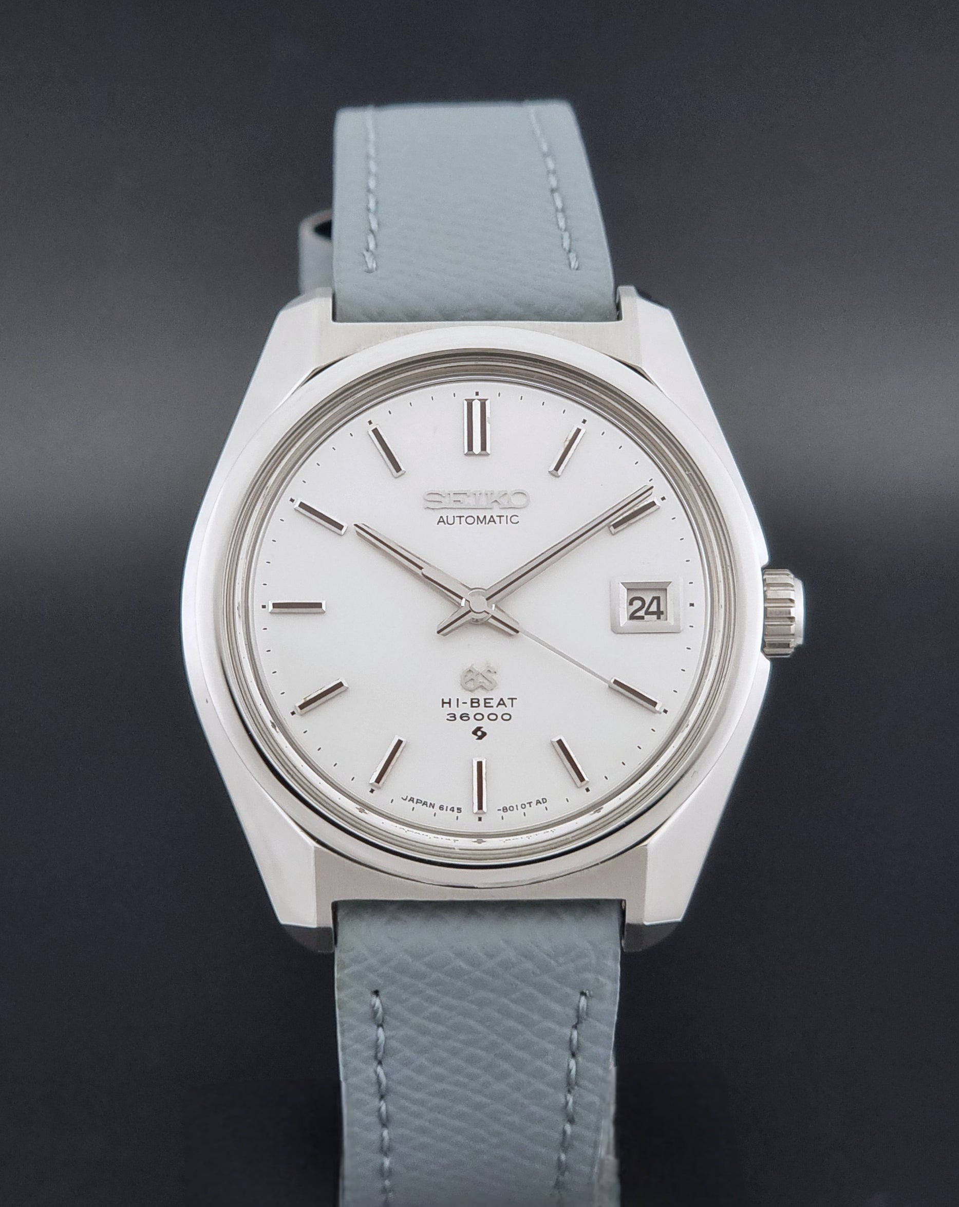 Vintage Grand Seiko 6145-8000 on a grey leather strap on a dark background close dial view