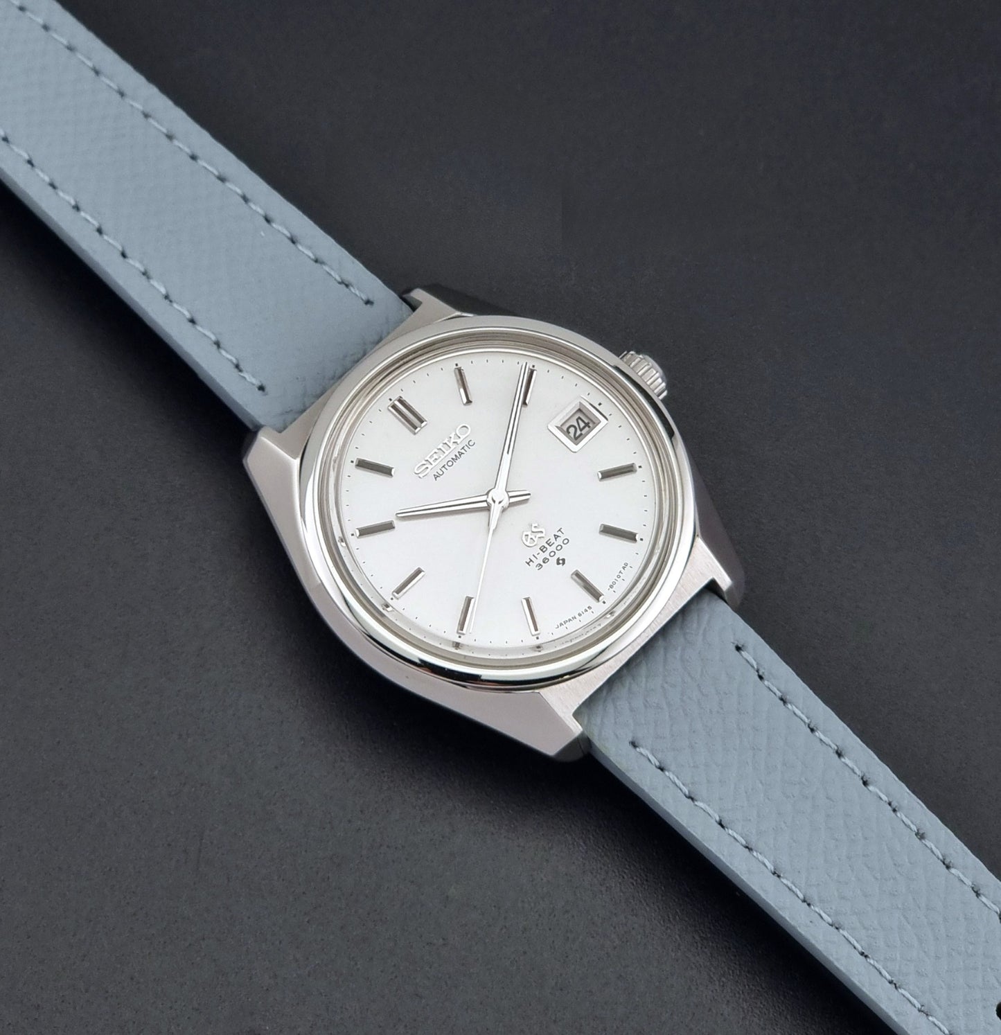 Vintage Grand Seiko 6145-8000 on a grey leather strap on a dark background  dial