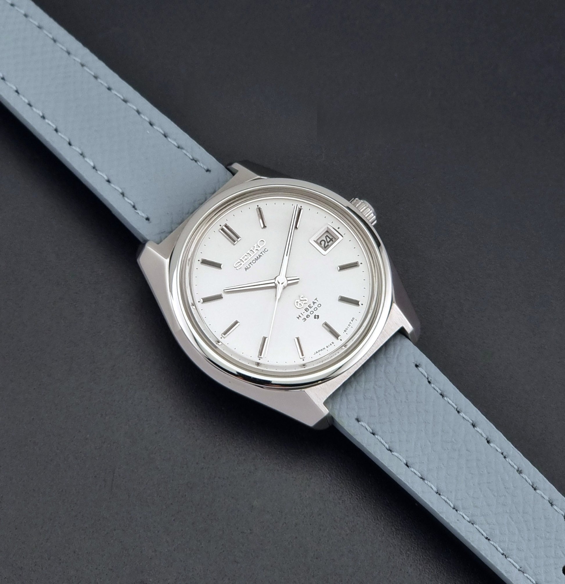 Vintage Grand Seiko 6145-8000 on a grey leather strap on a dark background  dial