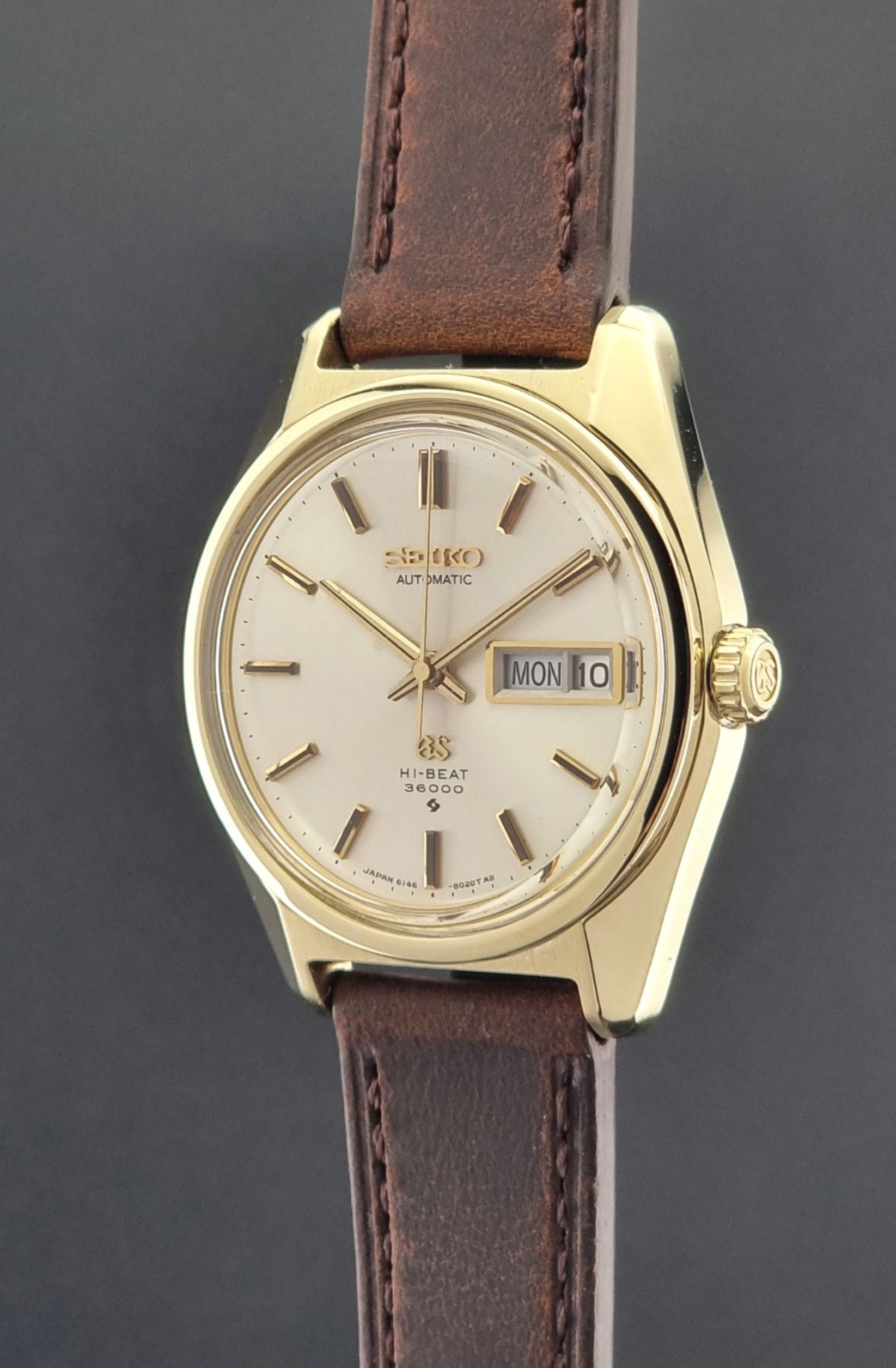 Vintage Grand Seiko watch 6146-8000 in gold with a brown leather strap crown side profile view