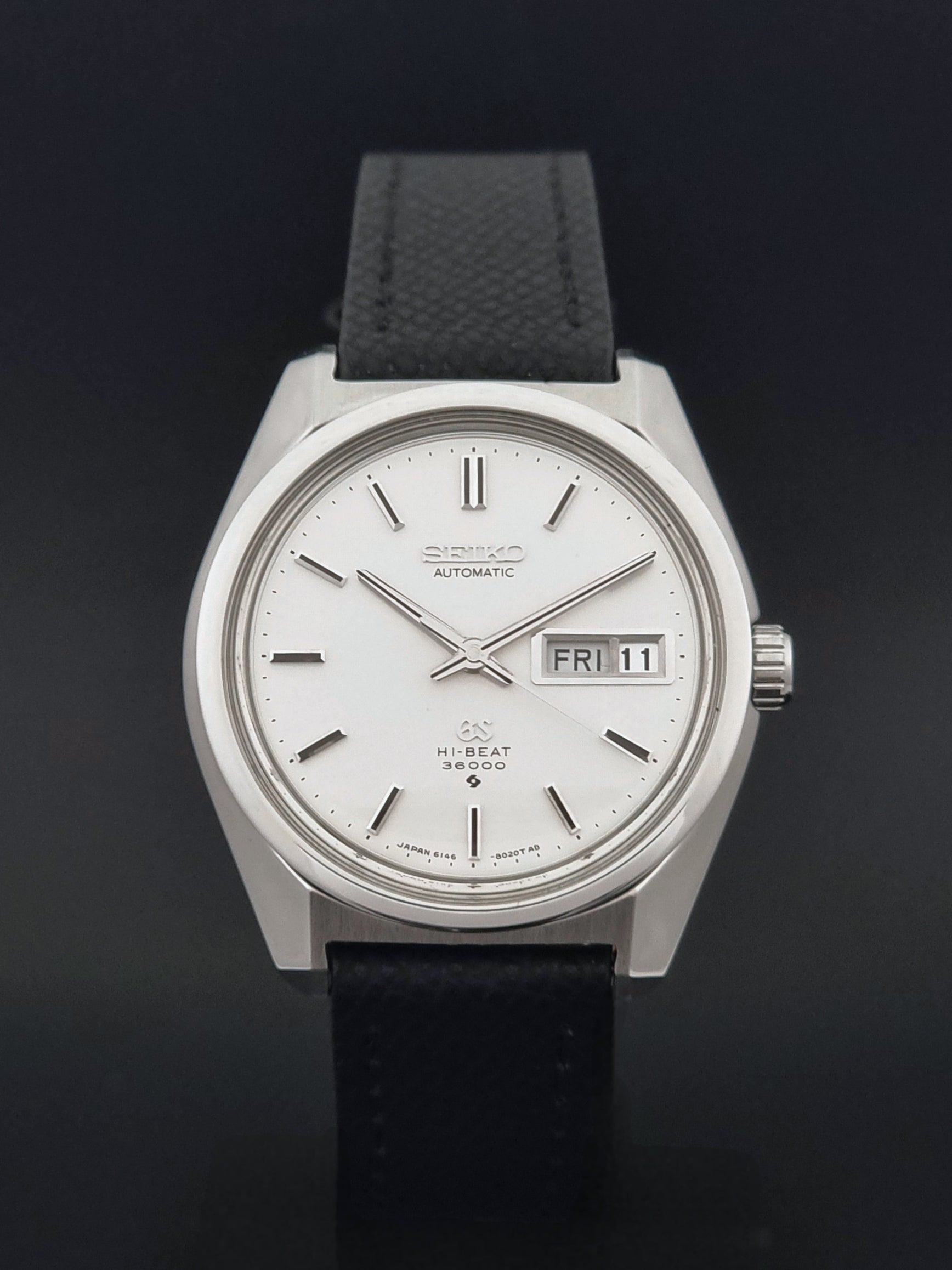Vintage Grand Seiko 6146-8000 Wristwatch with a black leather strap on a dark background close dial view