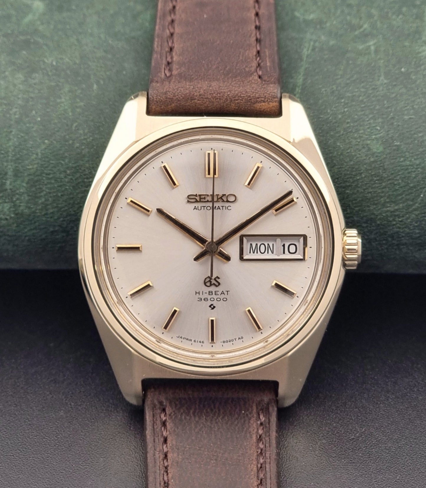 Vintage Grand Seiko watch 6146-8000 in gold with a brown leather strap close up front