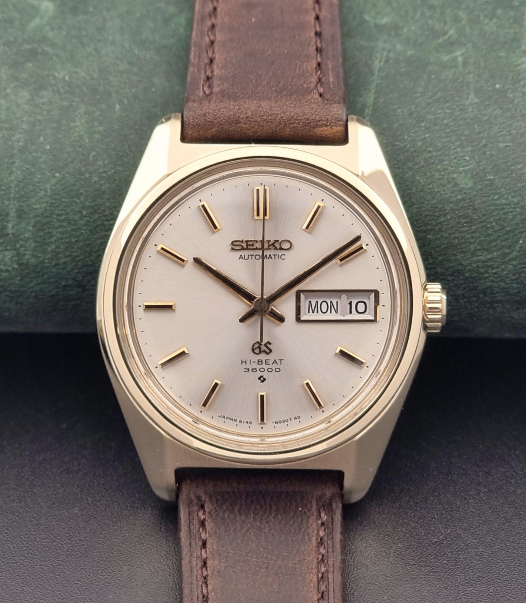 Vintage Grand Seiko watch 6146-8000 in gold with a brown leather strap close up front