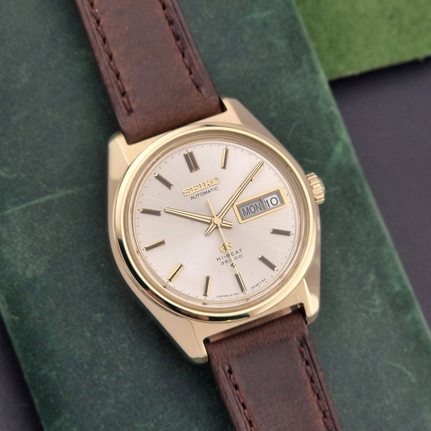 Vintage Grand Seiko watch 6146-8000 in gold with a brown leather strap close up