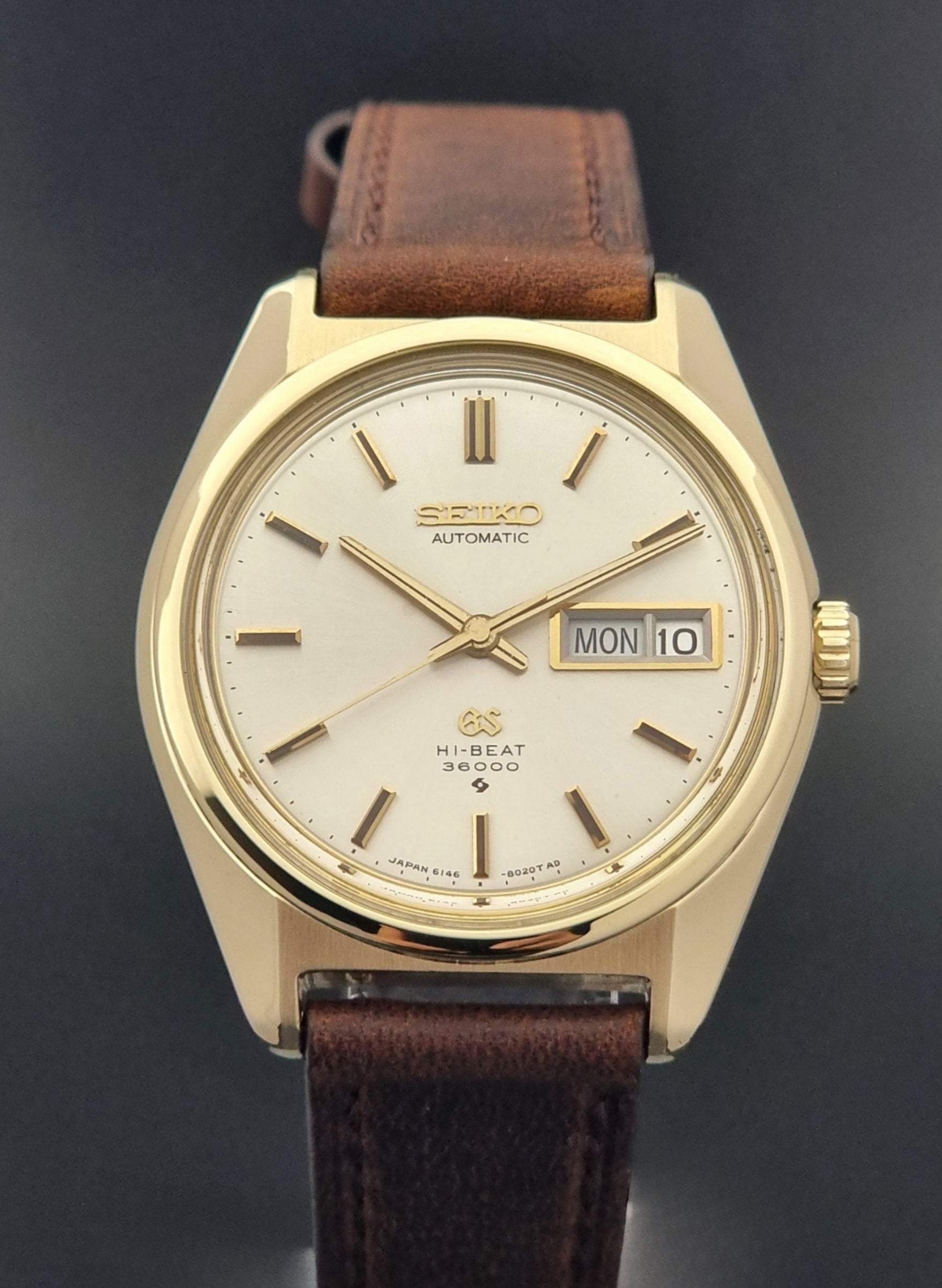 Vintage Grand Seiko watch 6146-8000 in gold with a brown leather strap front view