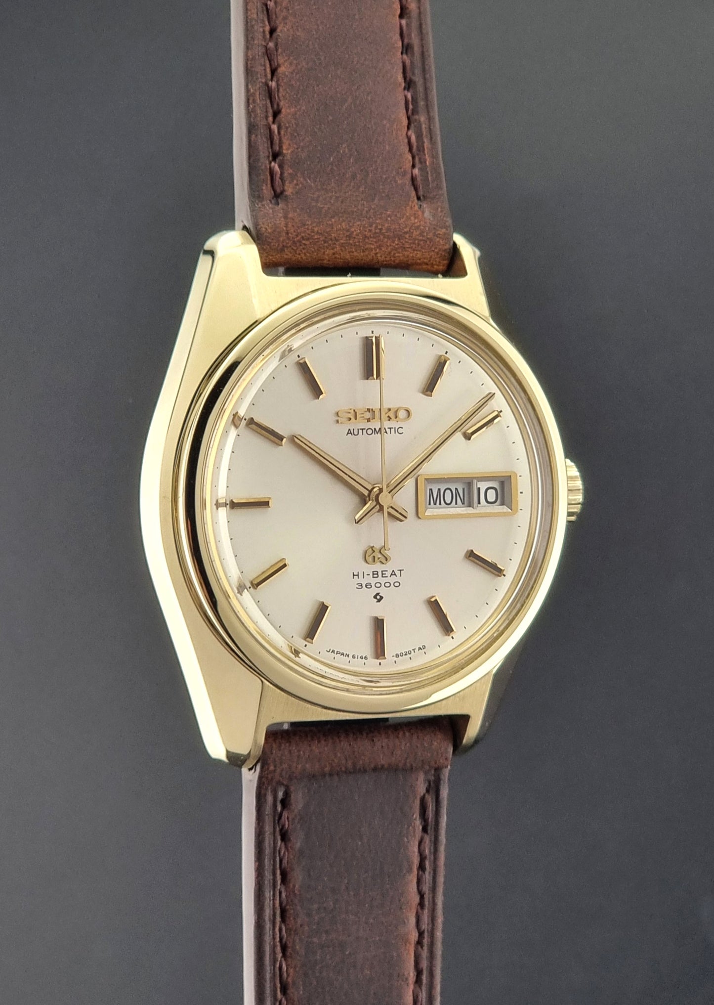 Vintage Grand Seiko watch 6146-8000 in gold with a brown leather strap side profile view