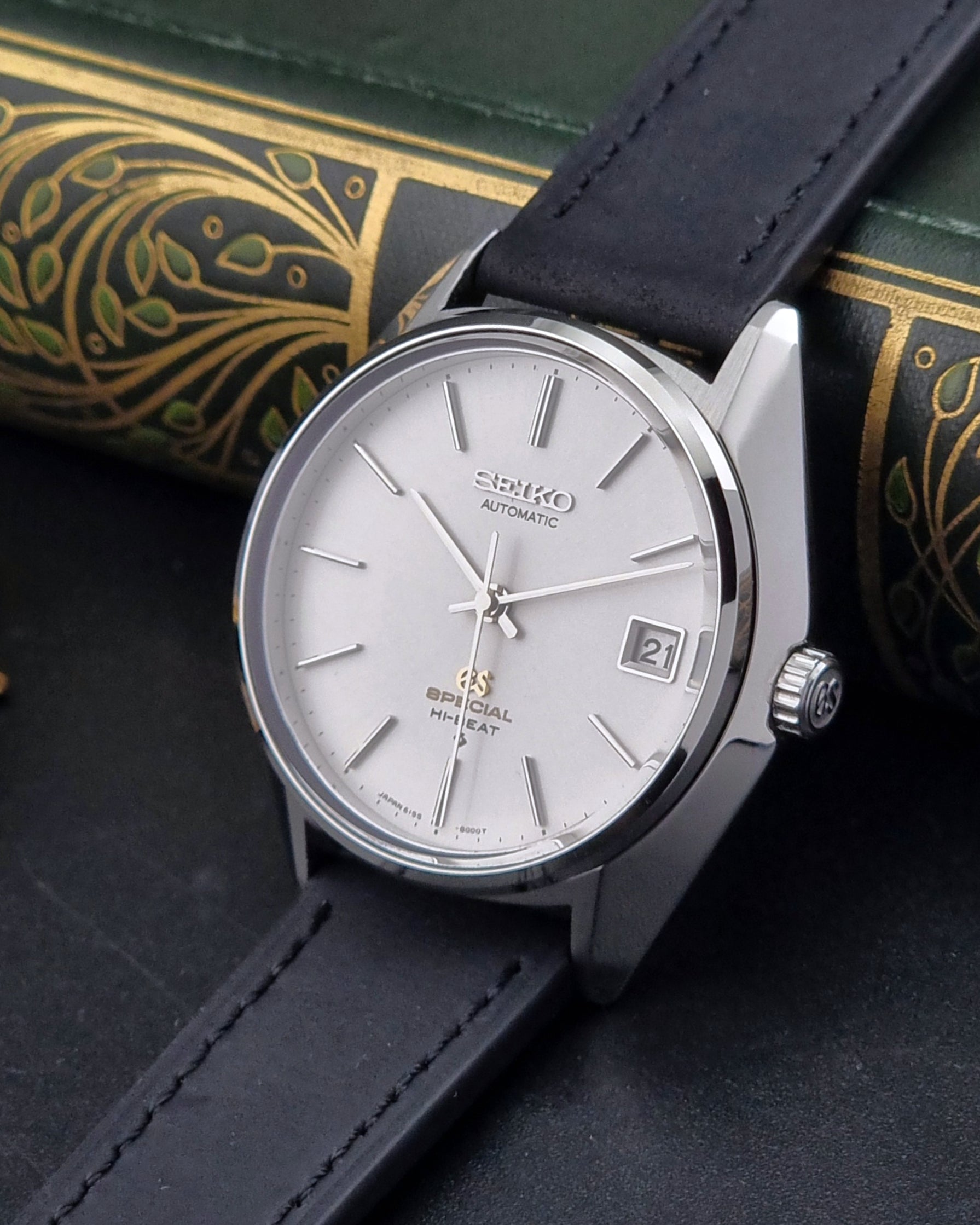 Vintage Grand Seiko Wristwatch with black strap and silver case on a dark surface