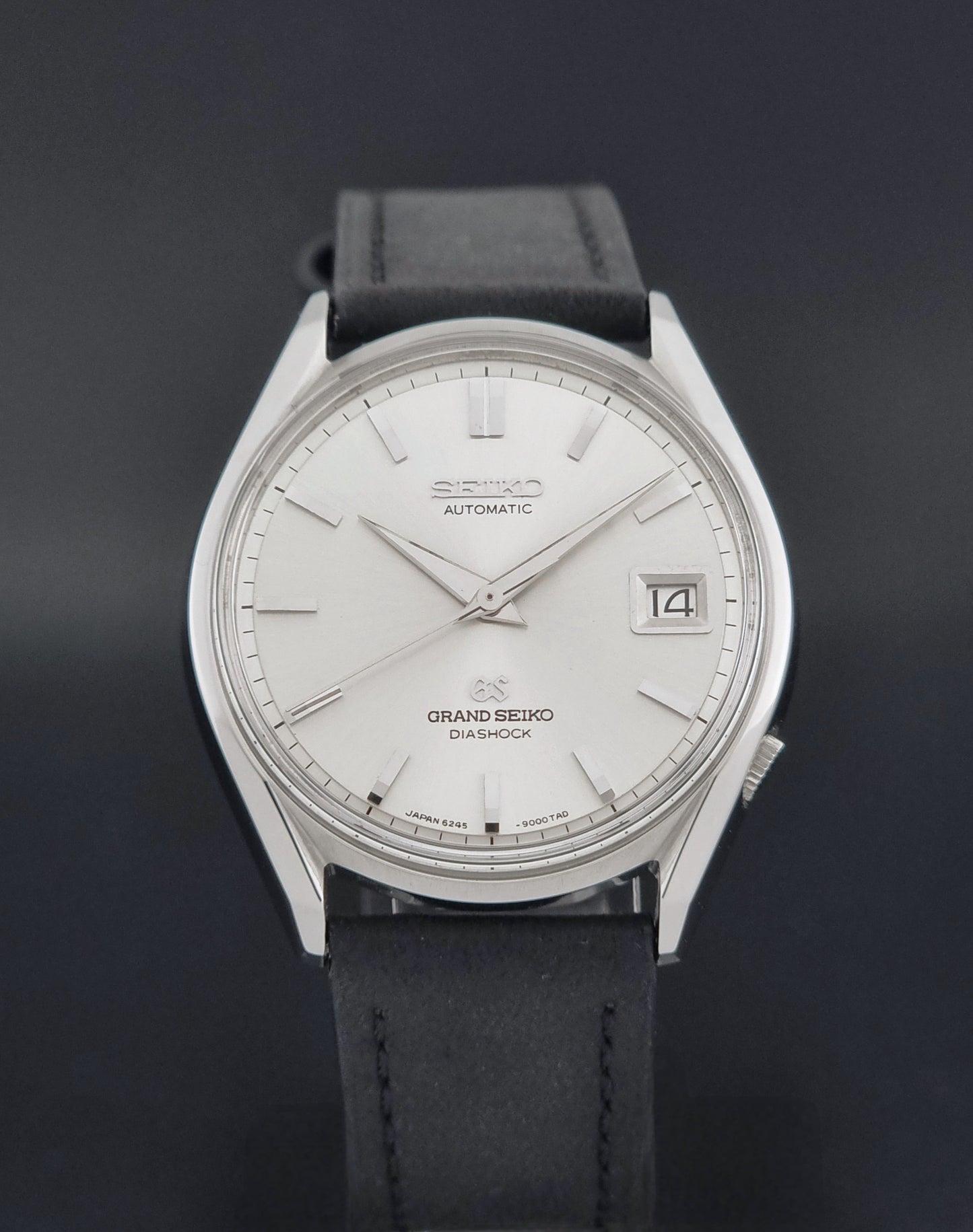 Vintage Grand Seiko 6245-9001 Wristwatch with a black leather strap on a dark background close dial view