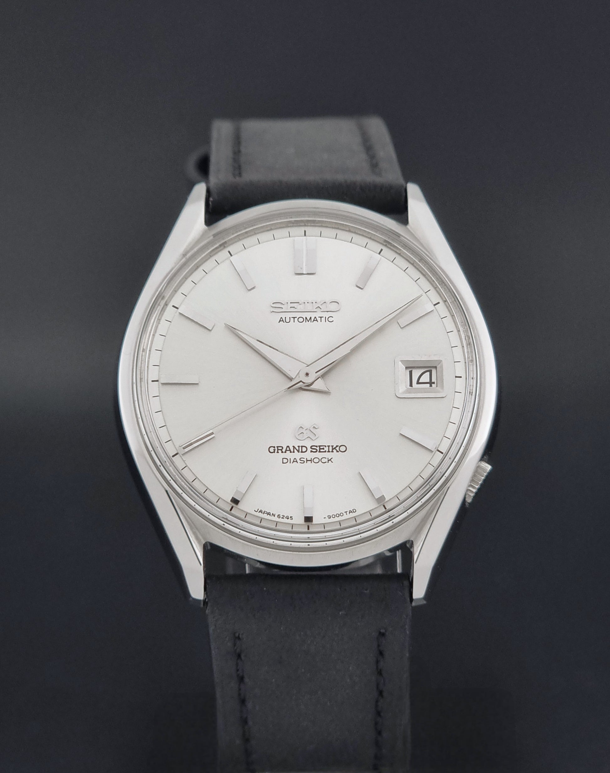 Vintage Grand Seiko 6245-9001 Wristwatch with a black leather strap on a dark background close dial view