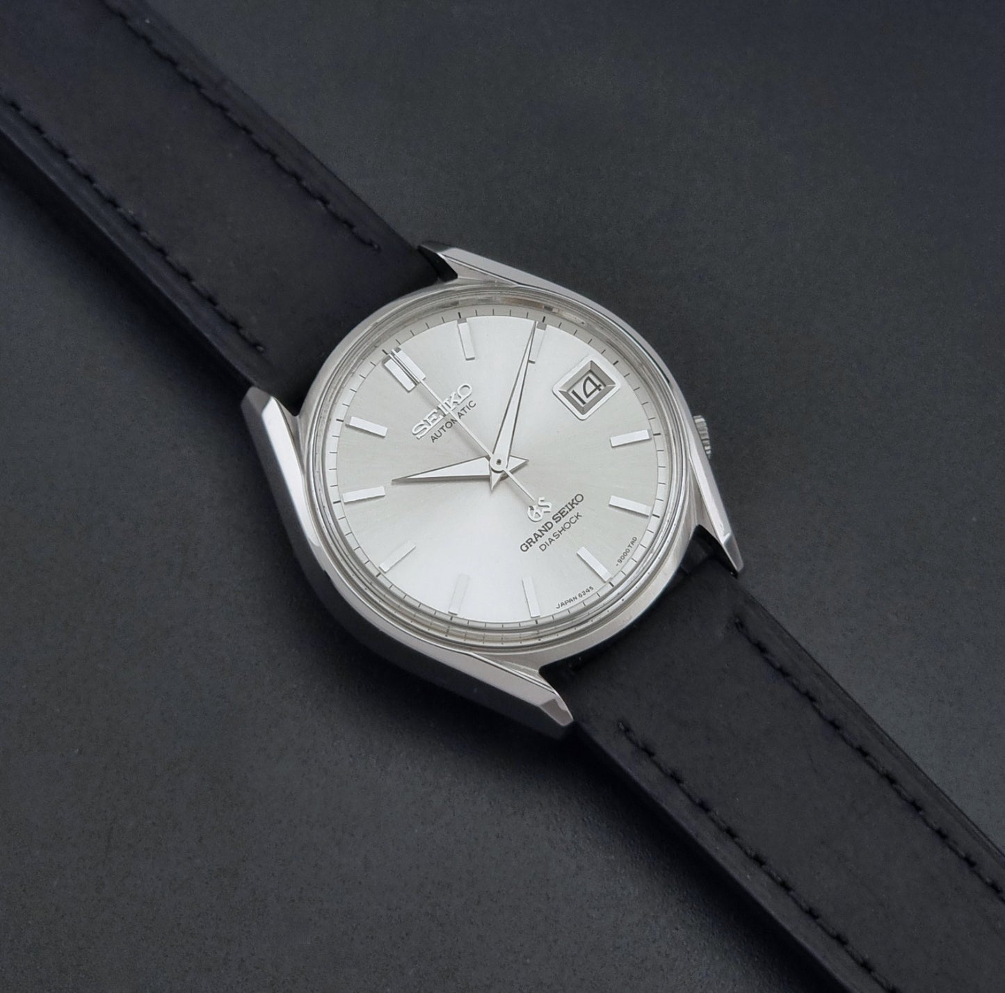 Vintage Grand Seiko 6245-9001 Wristwatch with a black leather strap on a dark background dial