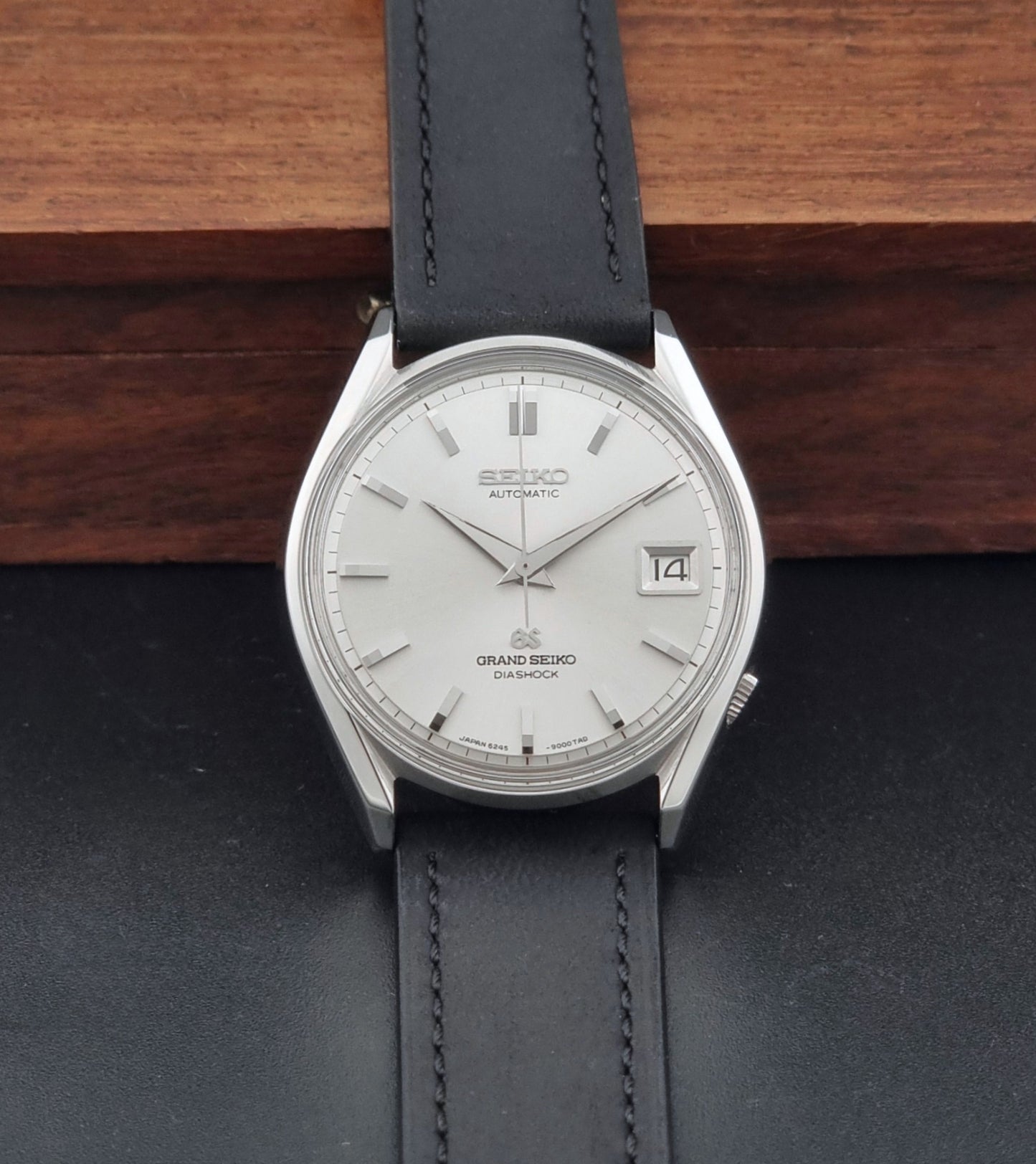 Vintage Grand Seiko 6245-9001 Wristwatch with a black leather strap on a dark background dial view
