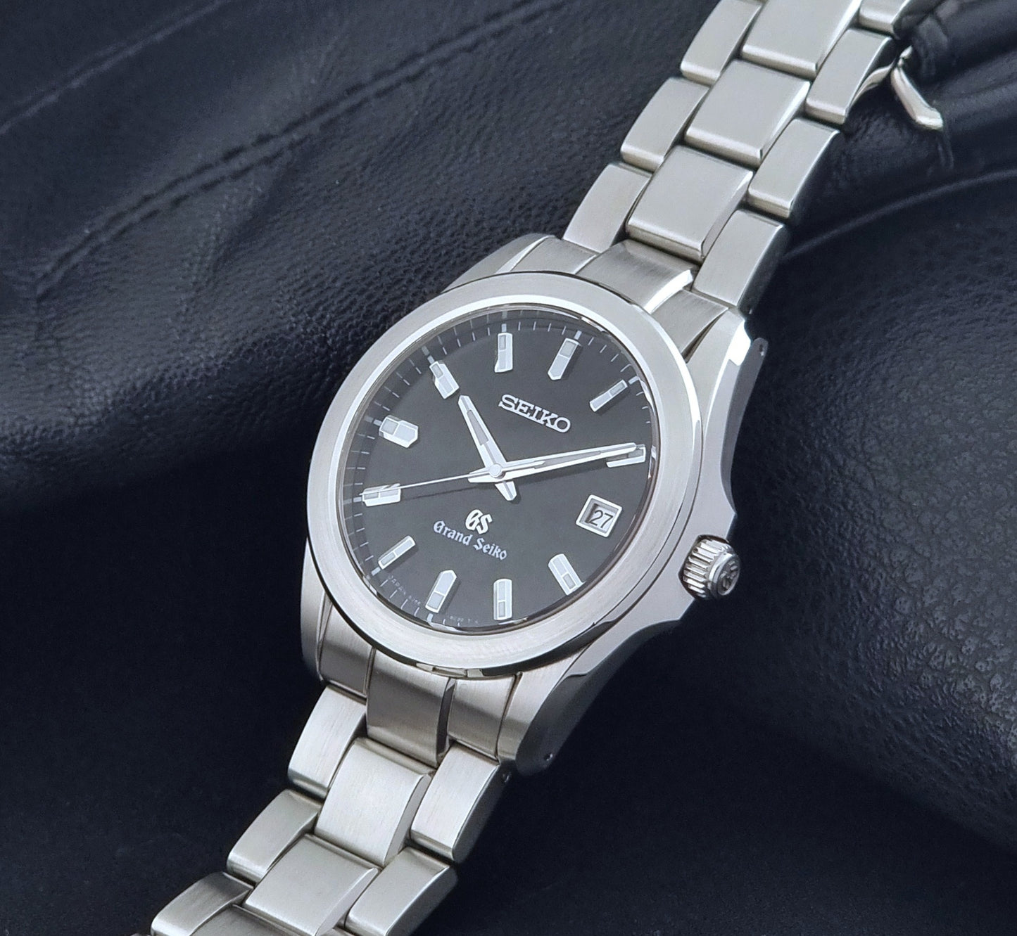 Grand Seiko quartz watch 8J56-8020 with a dark face on a dark background crown view