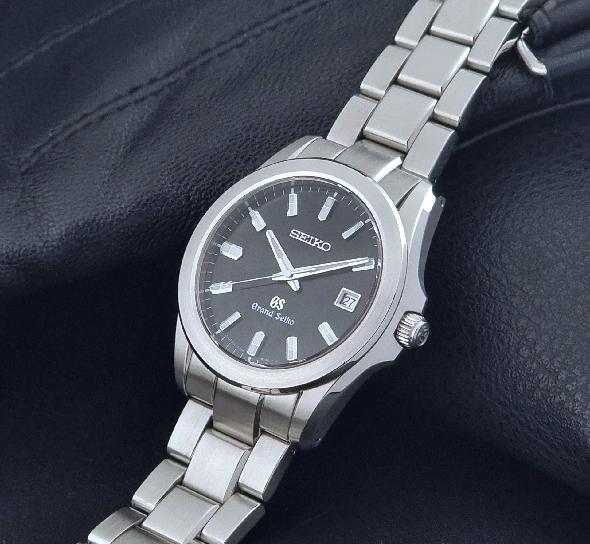 Grand Seiko quartz watch 8J56-8020 with a dark face on a dark background crown view