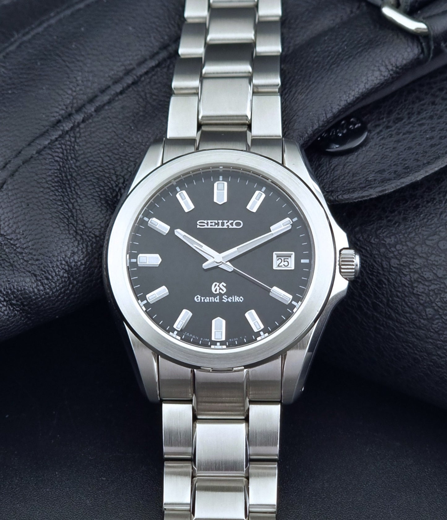 Grand Seiko quartz watch 8J56-8020 with a dark face on a dark background dial view