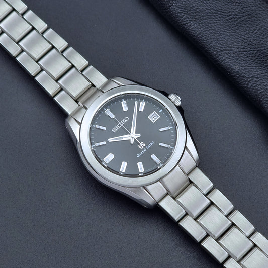 Grand Seiko quartz watch 8J56-8020 with a dark face on a dark background dial