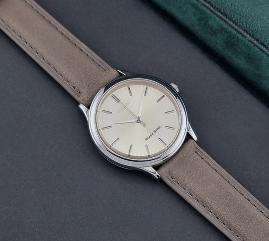 Vintage Grand Seiko watch 9581-7000 Quartz on a grey leather strap on a dark surface front