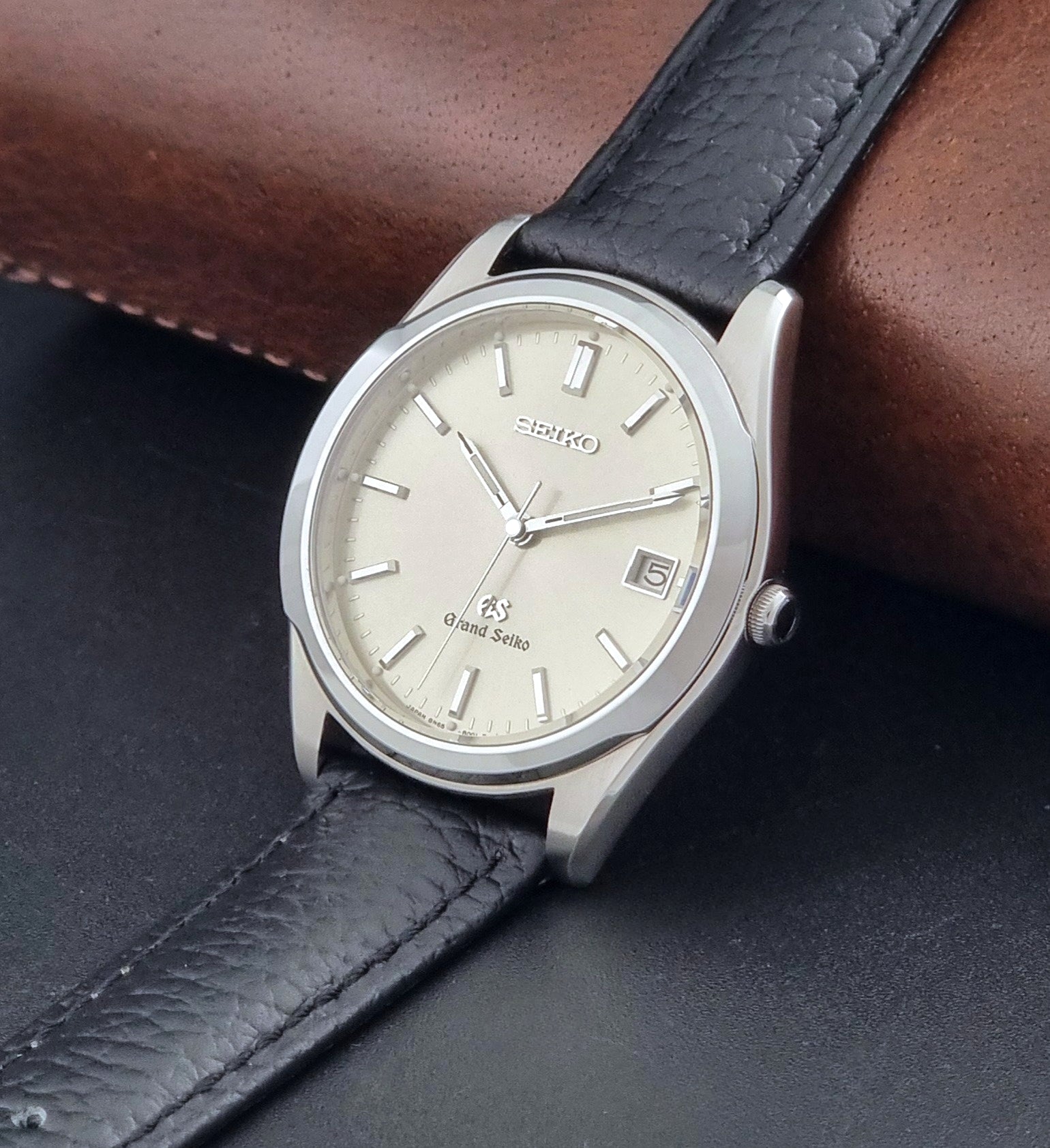 Vintage Grand Seiko SBGG003 watch  8N65-8000 with black leather strap on a dark surface crown view