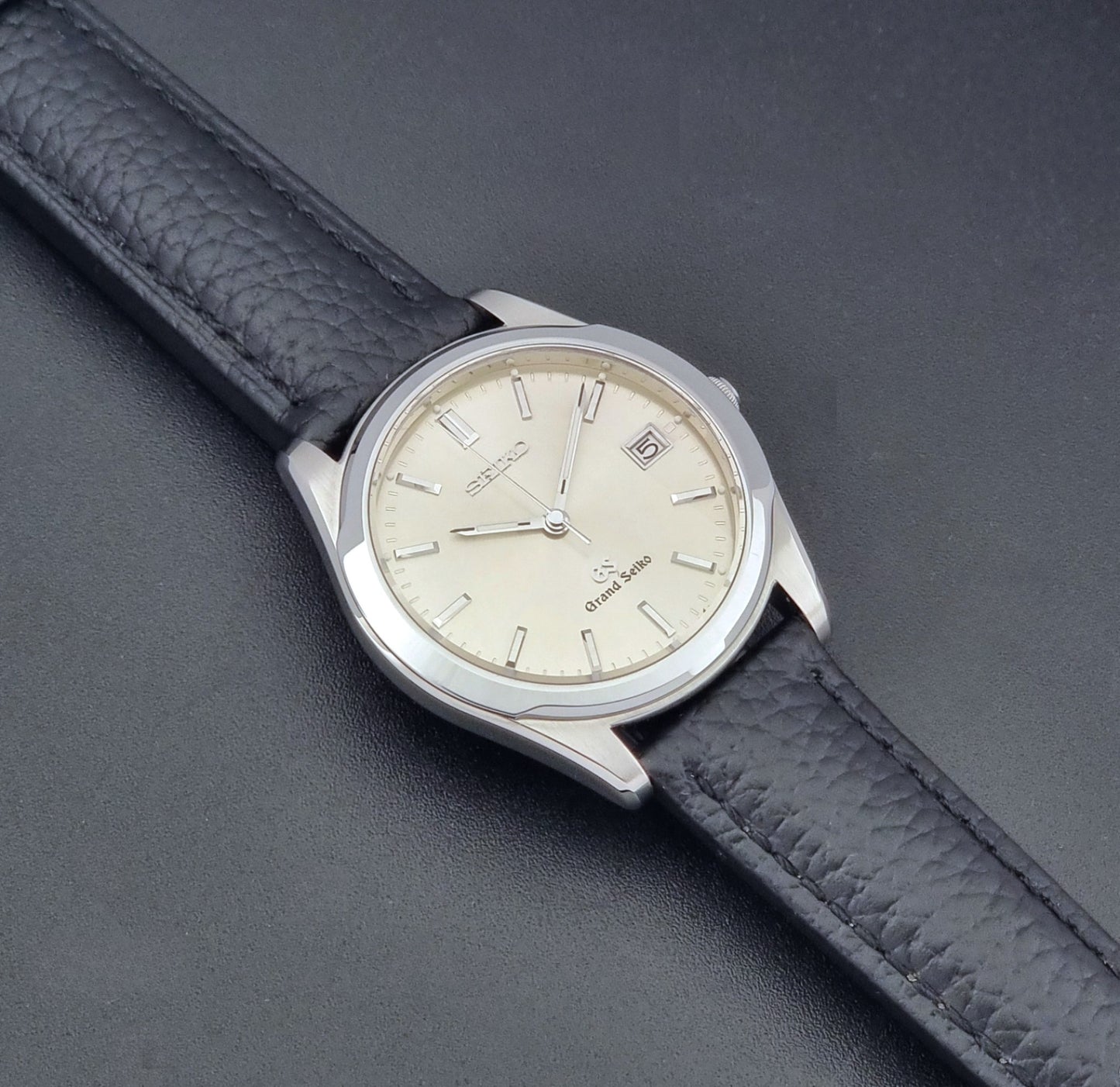 Vintage Grand Seiko SBGG003 watch  8N65-8000 with black leather strap on a dark surface dial