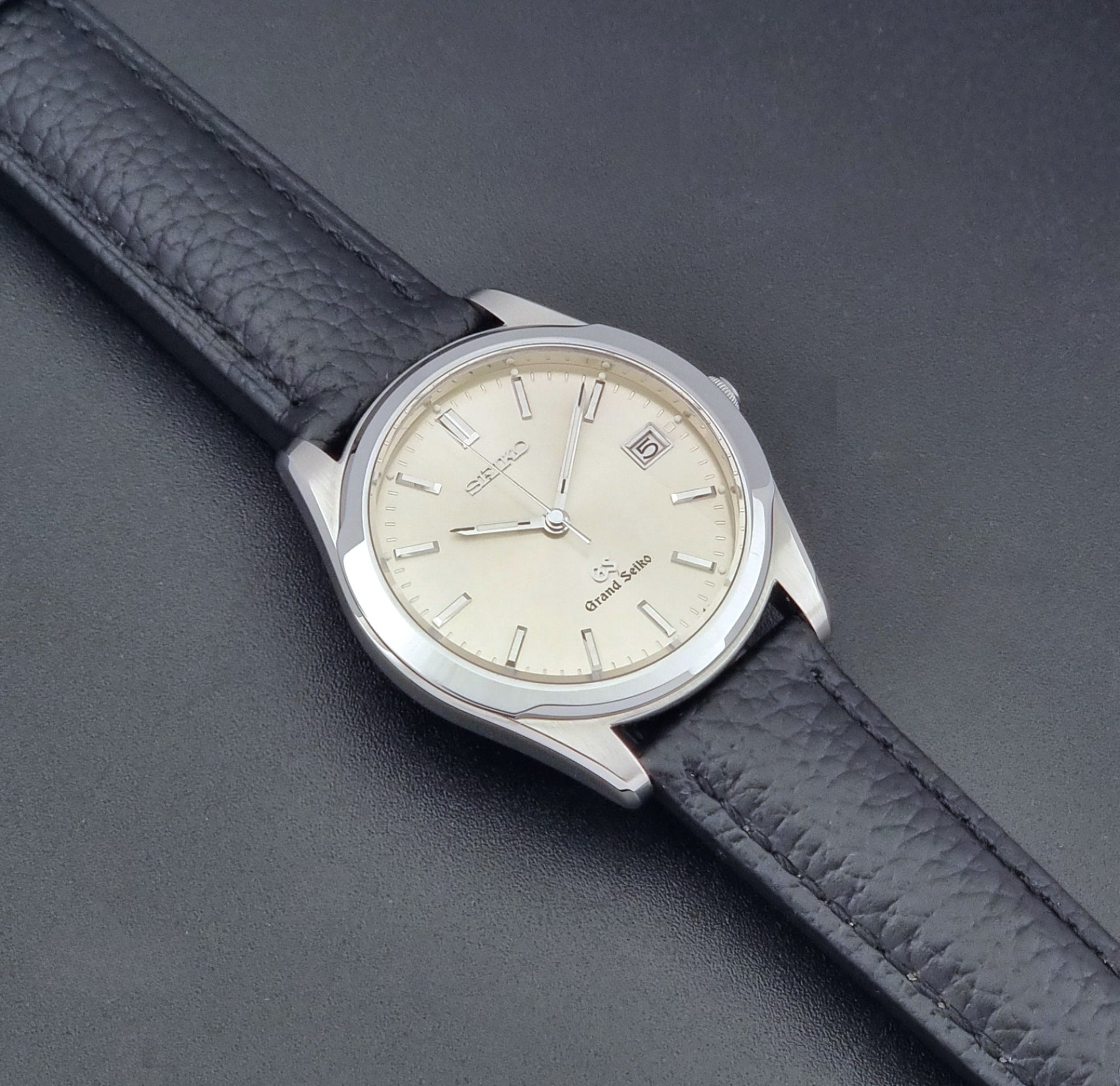 Vintage Grand Seiko SBGG003 watch  8N65-8000 with black leather strap on a dark surface dial