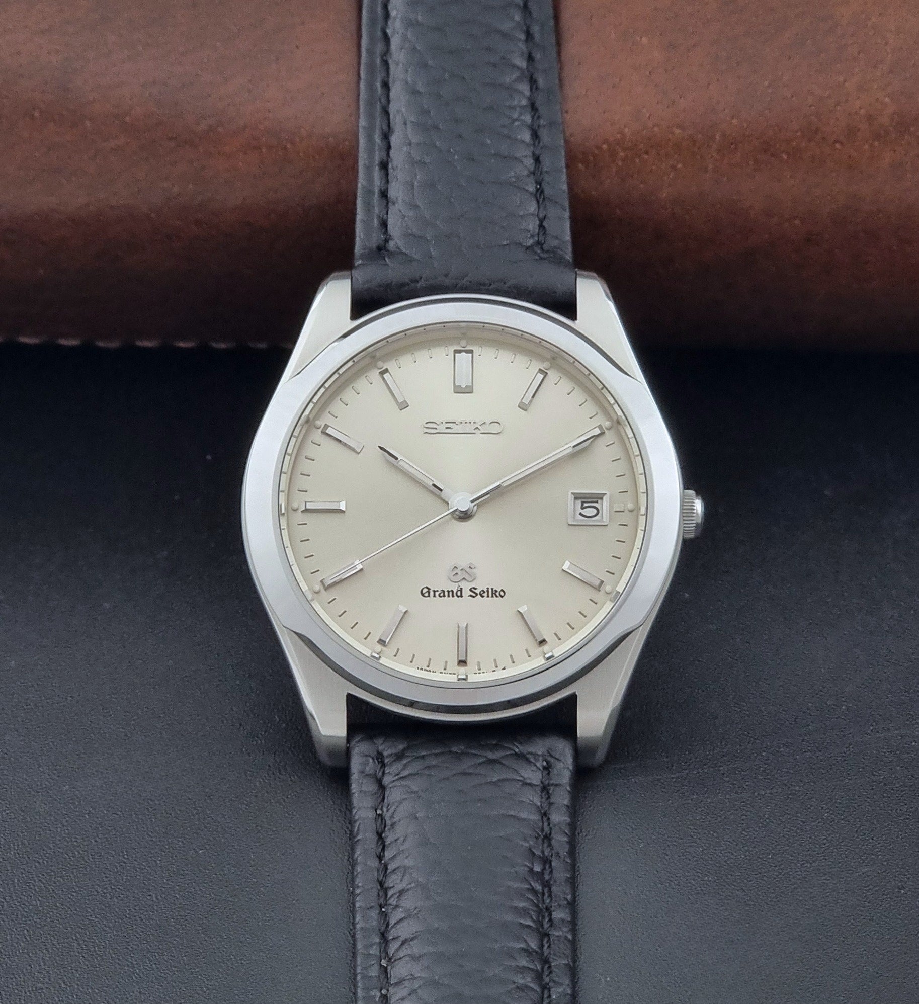 Vintage Grand Seiko SBGG003 watch  8N65-8000 with black leather strap on a dark surface dial view