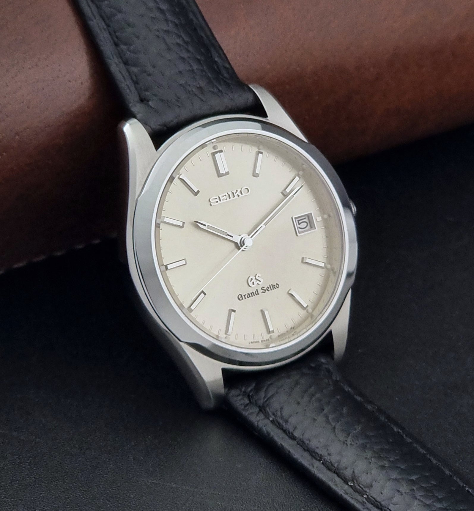 Vintage Grand Seiko SBGG003 watch  8N65-8000 with black leather strap on a dark surface side view