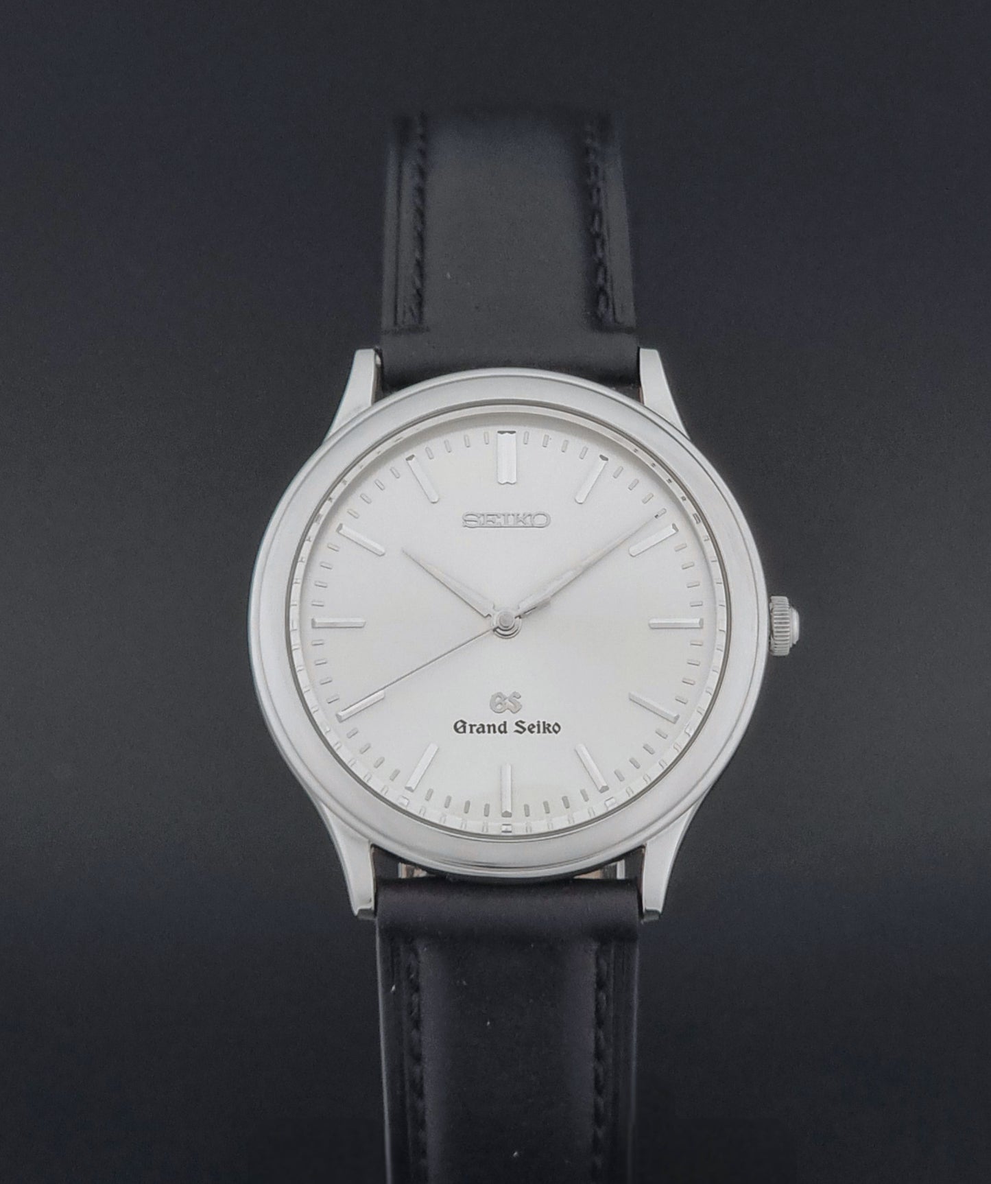 Vintage Grand Seiko 9581-7000 Quartz with black strap and silver case on a brown background close dial view