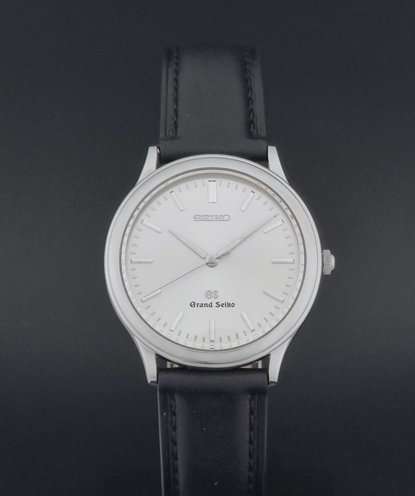 Vintage Grand Seiko 9581-7000 Quartz with black strap and silver case on a brown background close dial view