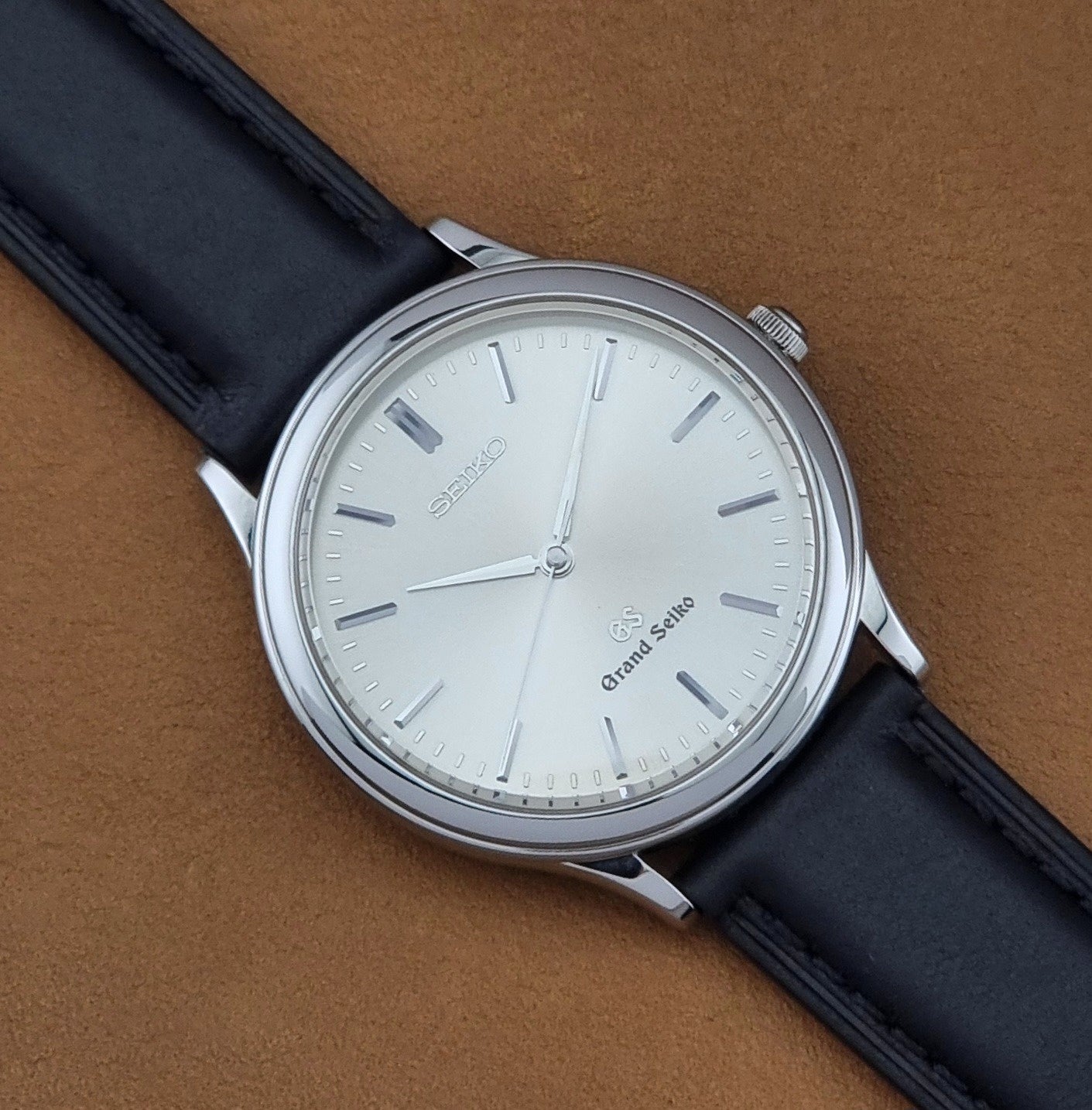 Vintage Grand Seiko 9581-7000 Quartz with black strap and silver case on a brown background close up dial view