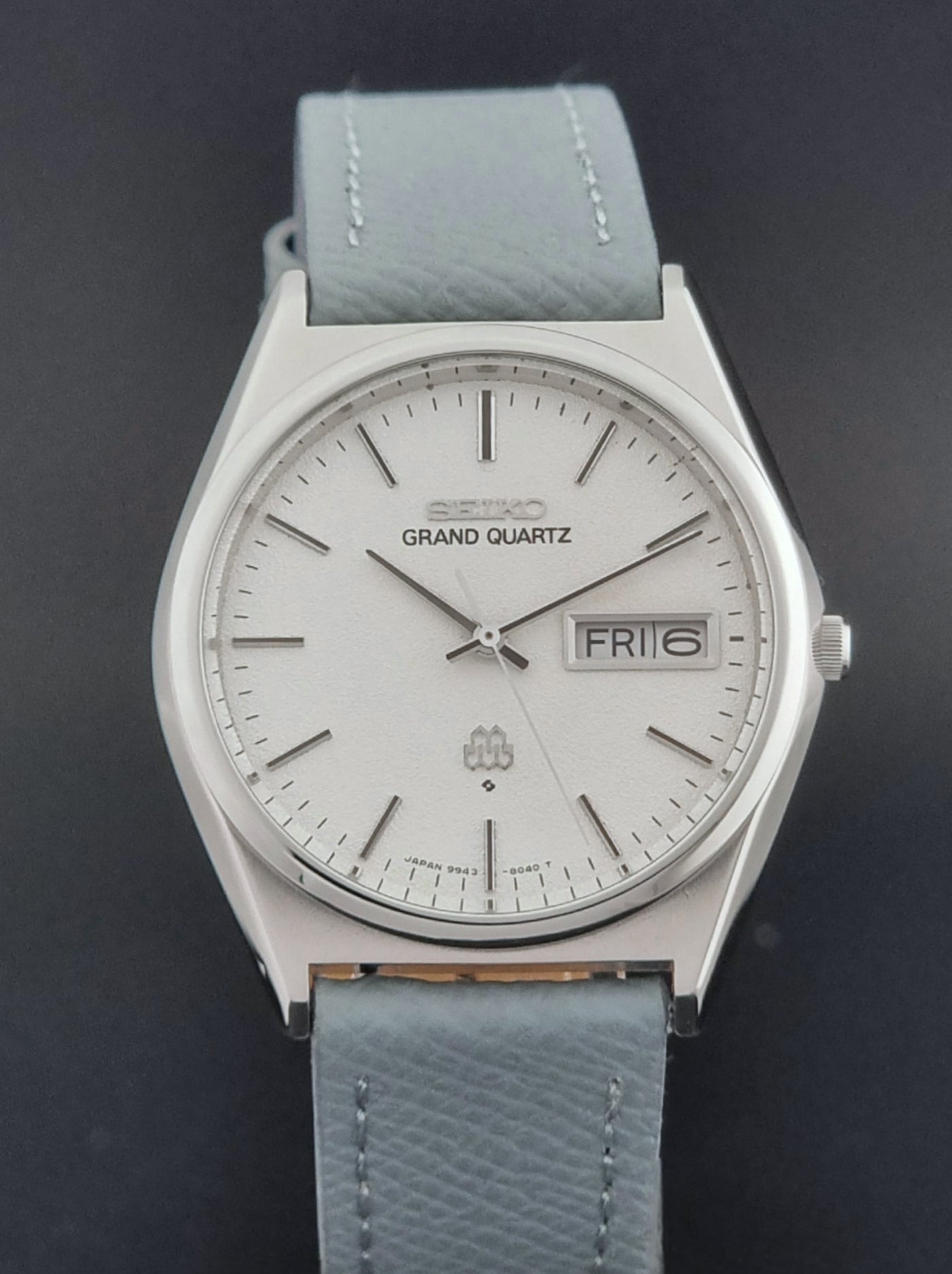 Vintage Seiko Grand Quartz watch 9943-8030 with a leather strap on a dark gray background close dial view