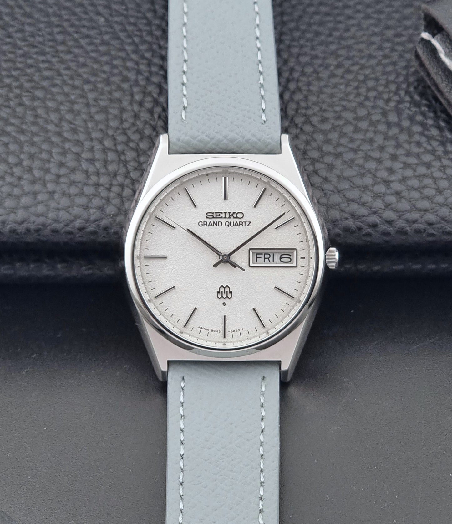 Vintage Seiko Grand Quartz watch 9943-8030 with a leather strap on a dark gray background dial view