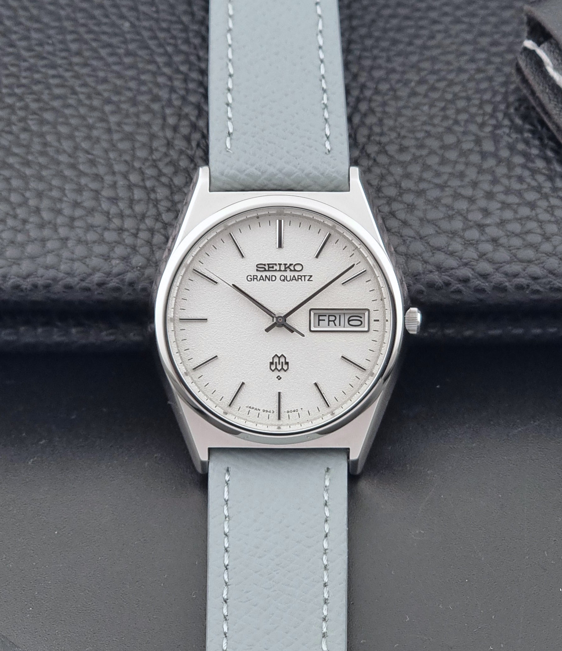 Vintage Seiko Grand Quartz watch 9943-8030 with a leather strap on a dark gray background dial view