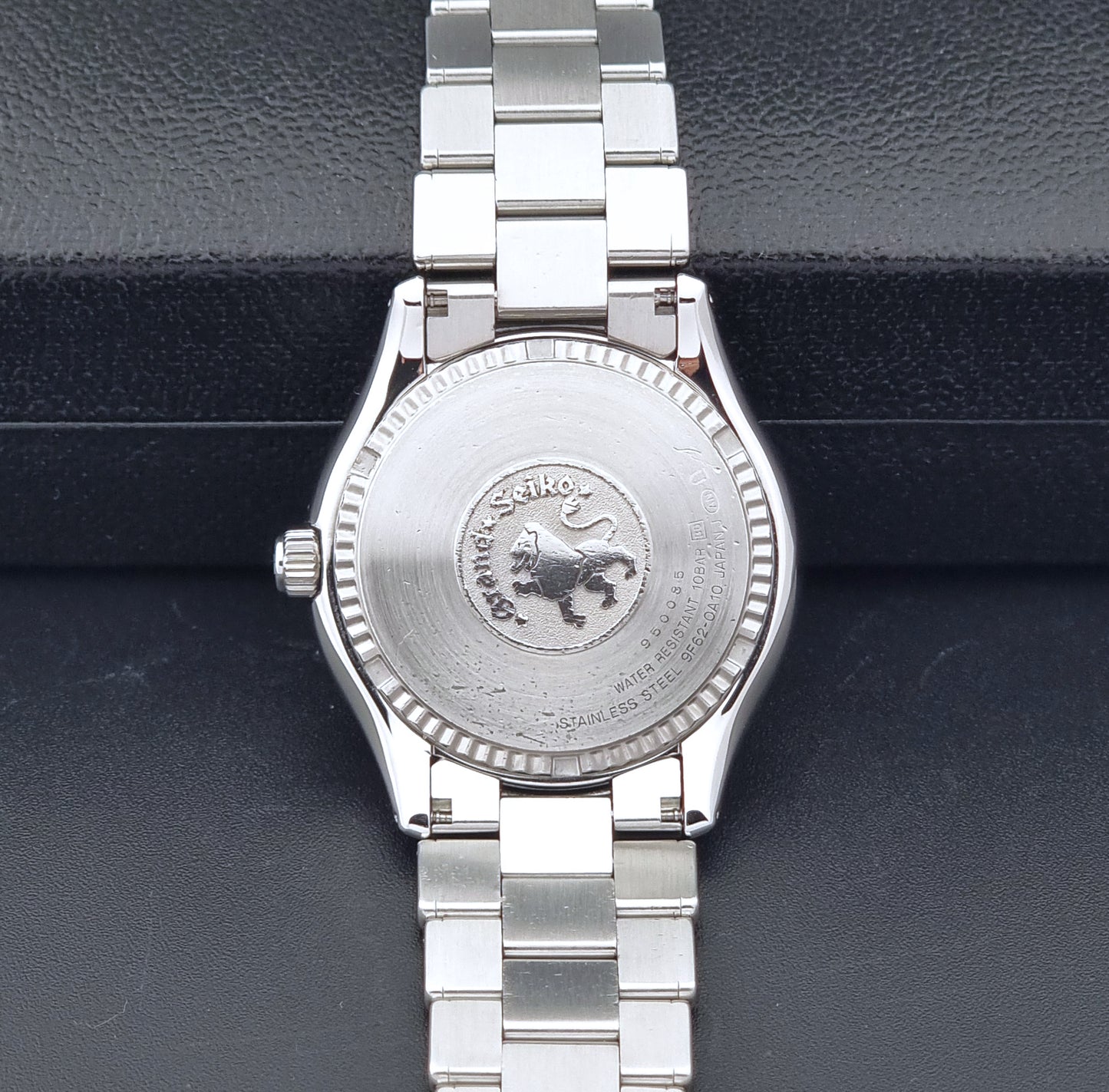 Grand Seiko SBGX005 quartz watch 9F62-0A10 with a detailed face on a dark textured surface case back view